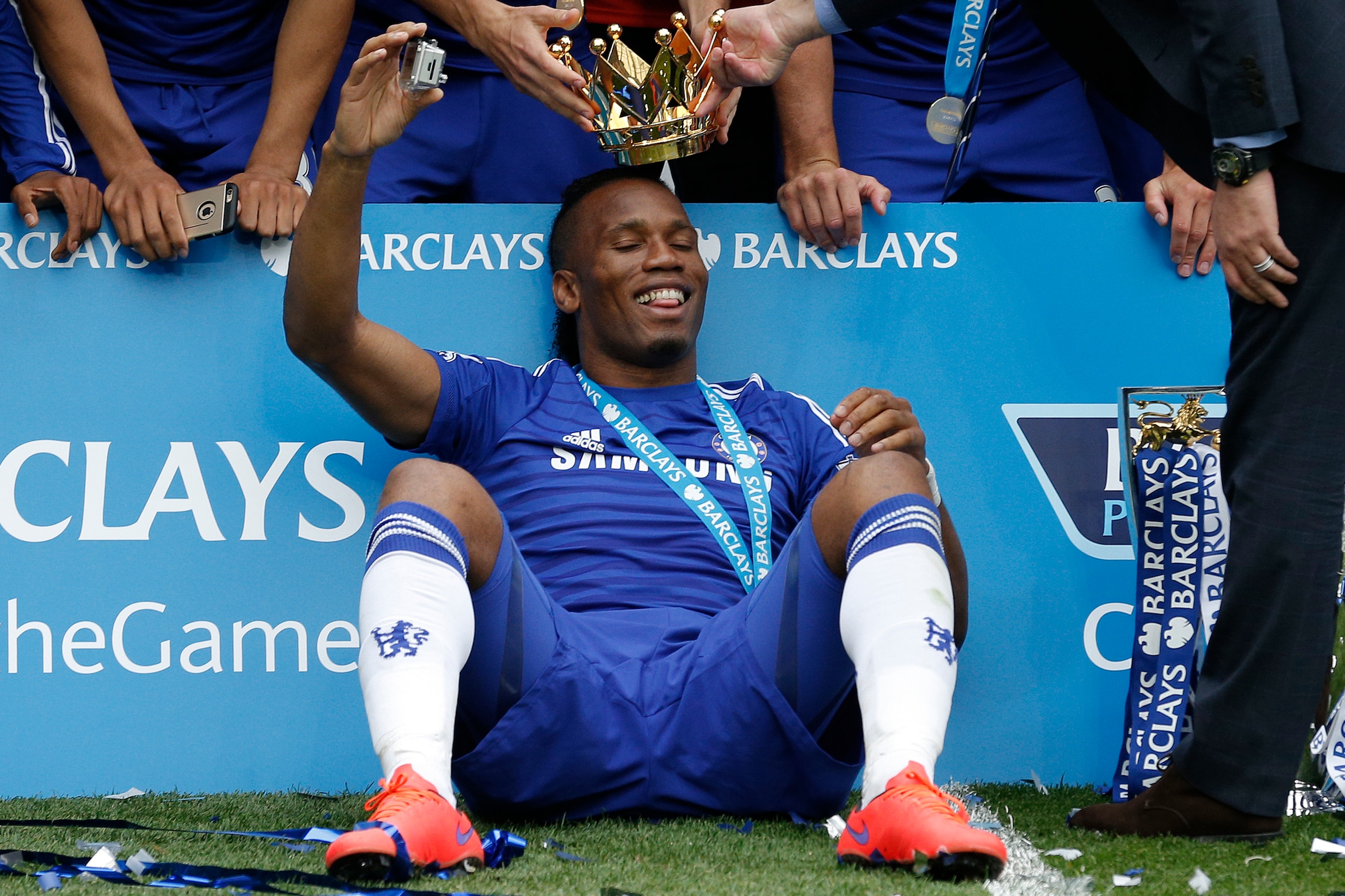Didier Drogba gets the crown from the Premier League trophy placed on his head by Jose Mourinho after the presentation during the Chelsea v Sunderland F.A. Premier League match at Stamford Bridge on May 24th 2015 in London (Photo by Tom Jenkins/Getty Imag