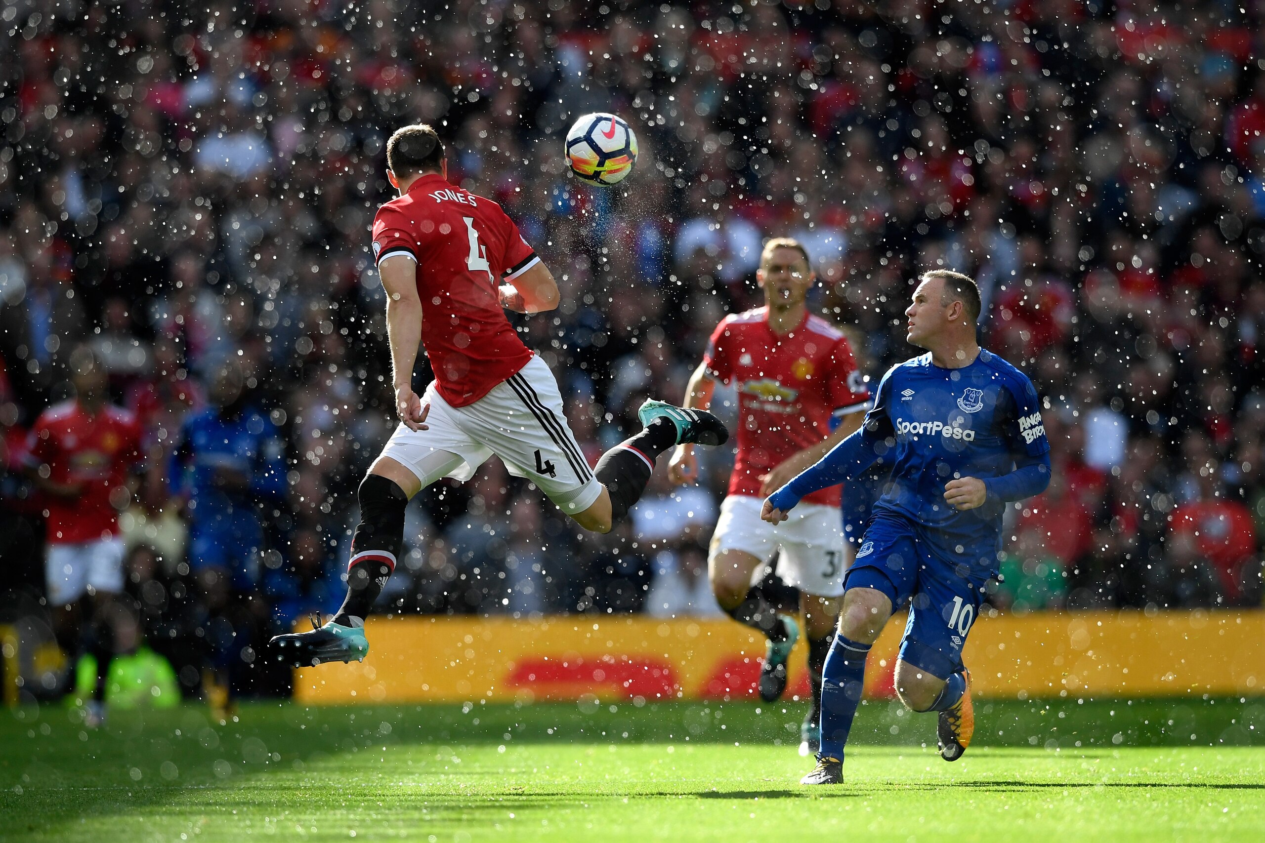 MANCHESTER, ENGLAND - SEPTEMBER 17: Phil Jones of Manchester United wins a header while under pressure from Wayne Rooney of Everton during the Premier League match between Manchester United and Everton at Old Trafford on September 17, 2017 in Manchester, 
