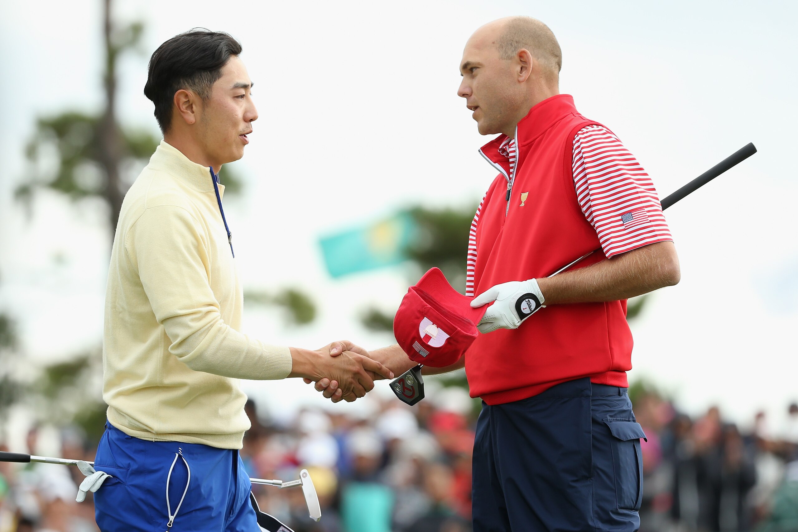 INCHEON CITY, SOUTH KOREA - OCTOBER 11:  Sang-Moon Bae of the International Team (L) shakes hands with Bill Haas of the United States Team on the 18h green after Haas won the match 2up during the Sunday singles matches at The Presidents Cup at Jack Nickla