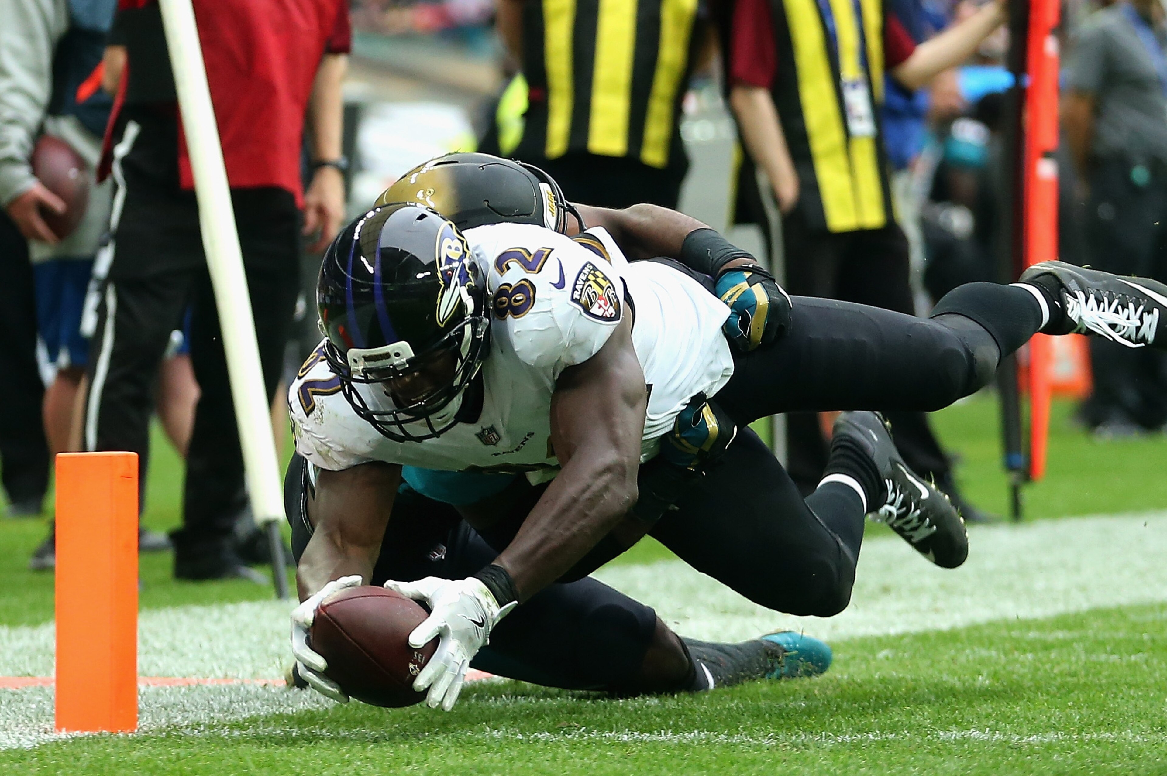 LONDON, ENGLAND - SEPTEMBER 24:   Benjamin Watson of the Baltimore Ravens breaks through  Donald Payne of the Jacksonville Jaguars as he scores a touchdown during the NFL International Series match between Baltimore Ravens and Jacksonville Jaguars at Wemb