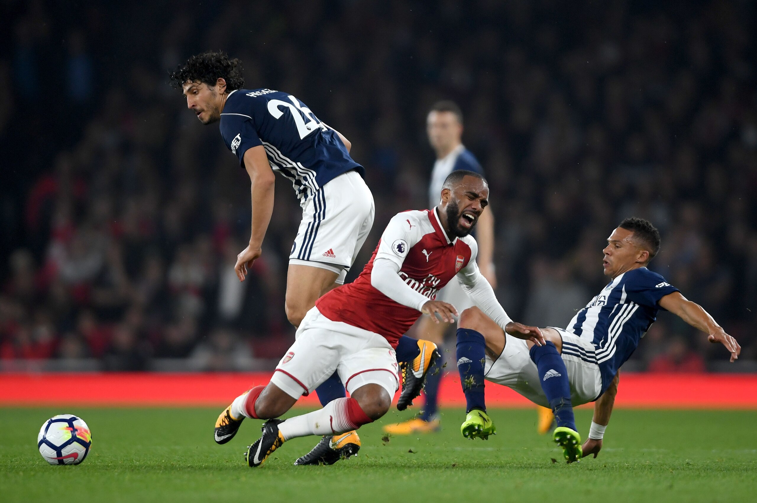 LONDON, ENGLAND - SEPTEMBER 25:  Alexandre Lacazette of Arsenal is challenged by Ahmed El-Sayed Hegazi and Kieran Gibbs of West Bromwich Albion during the Premier League match between Arsenal and West Bromwich Albion at Emirates Stadium on September 25, 2