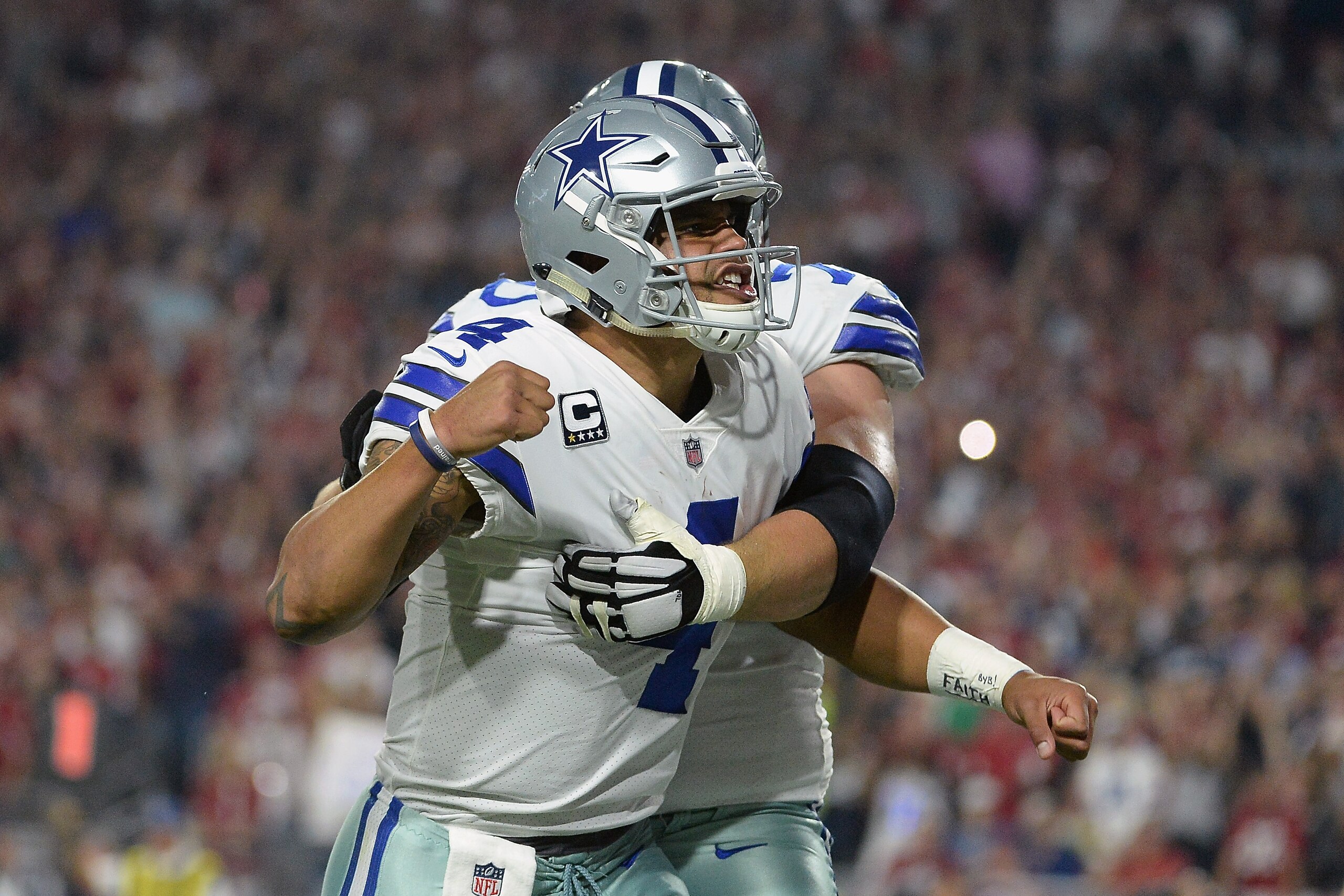 GLENDALE, AZ - SEPTEMBER 25:  Offensive guard Zack Martin #70 reacts with quarterback Dak Prescott #4 of the Dallas Cowboys after scoring on a ten yard run during the second quarter of the NFL game against the Arizona Cardinals at the University of Phoeni