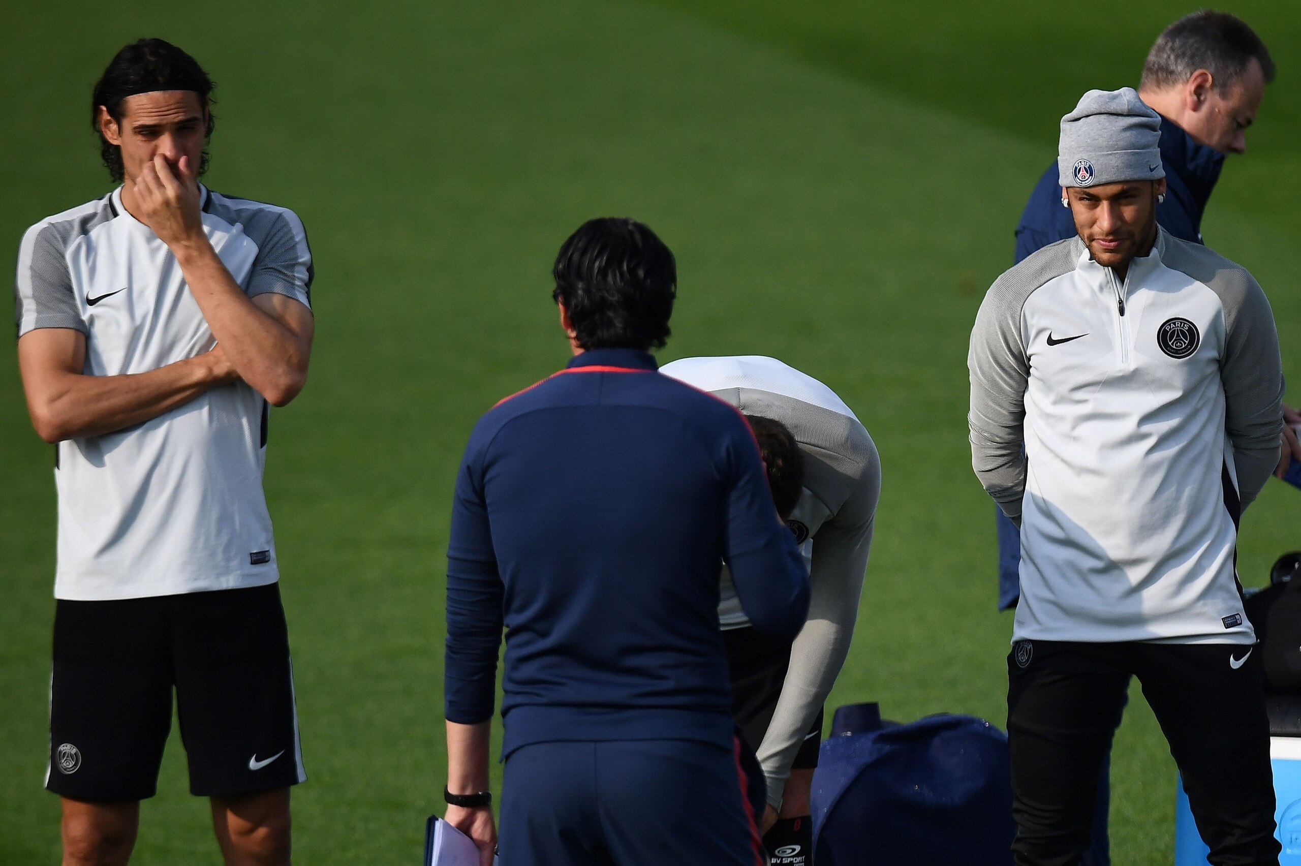 Paris Saint-Germain's Uruguayan forward Edinson Cavani (L) and Paris Saint-Germain's Brazilian forward Neymar (R) listen to Paris Saint-Germain's Spanish head coach Unai Emery (C) as they attend a training session on the eve of the UEFA Champions League f