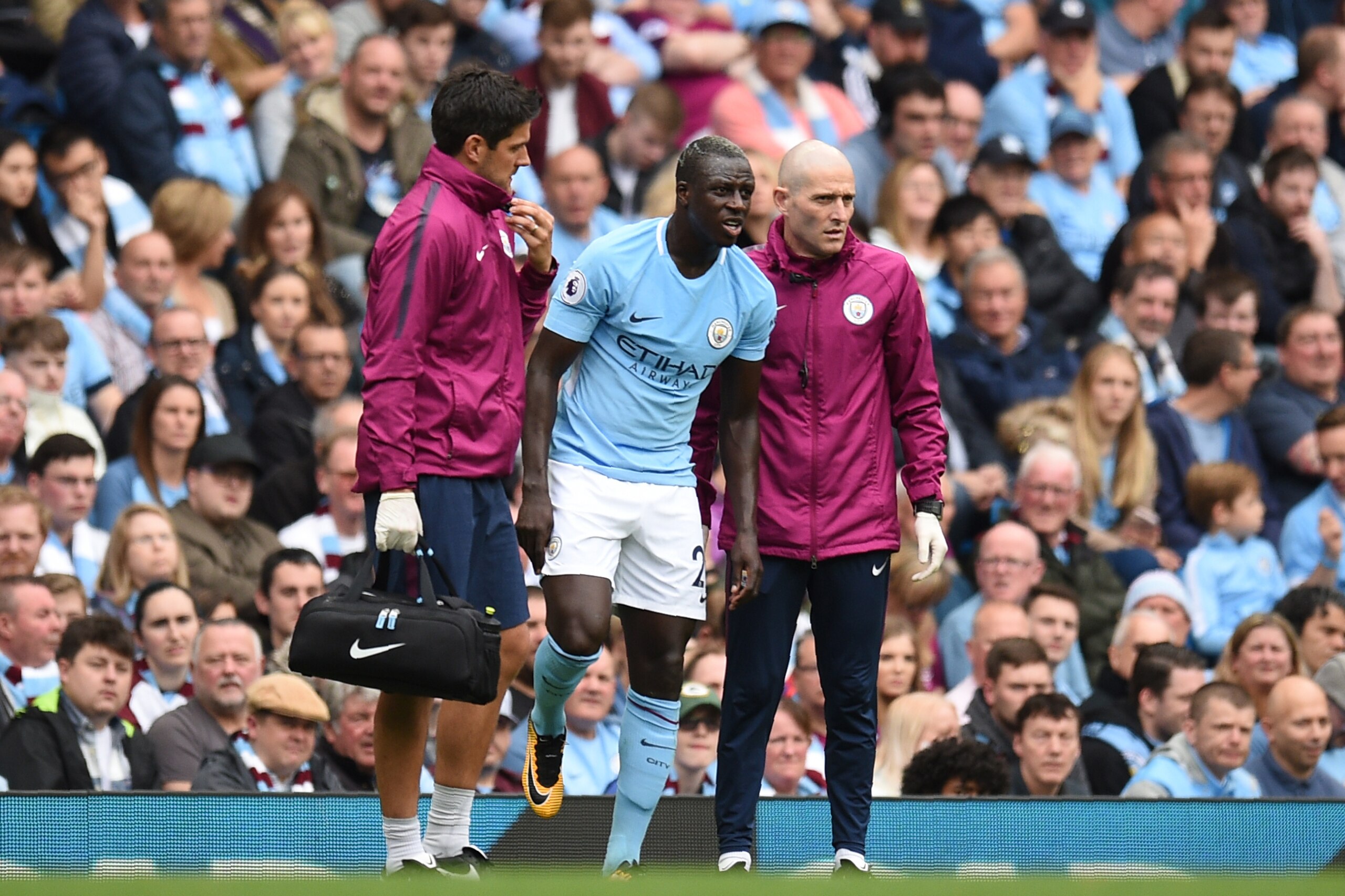 Manchester City's French defender Benjamin Mendy (C) is helped by medics during the English Premier League football match between Manchester City and Crystal Palace at the Etihad Stadium in Manchester, north west England, on September 23, 2017. / AFP PHOT