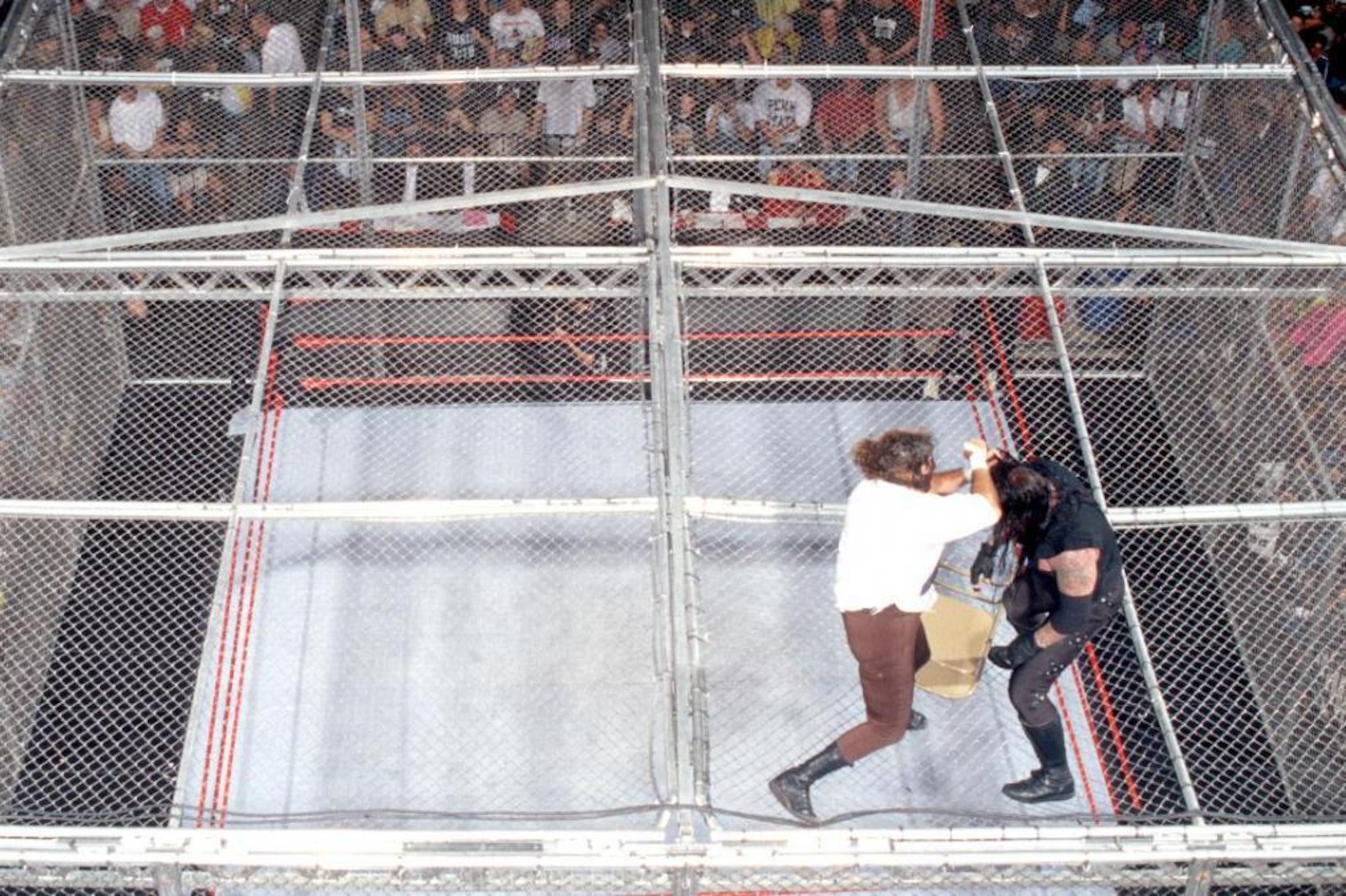 Foley and Undertaker battle on top of the Hell in the Cell cage.