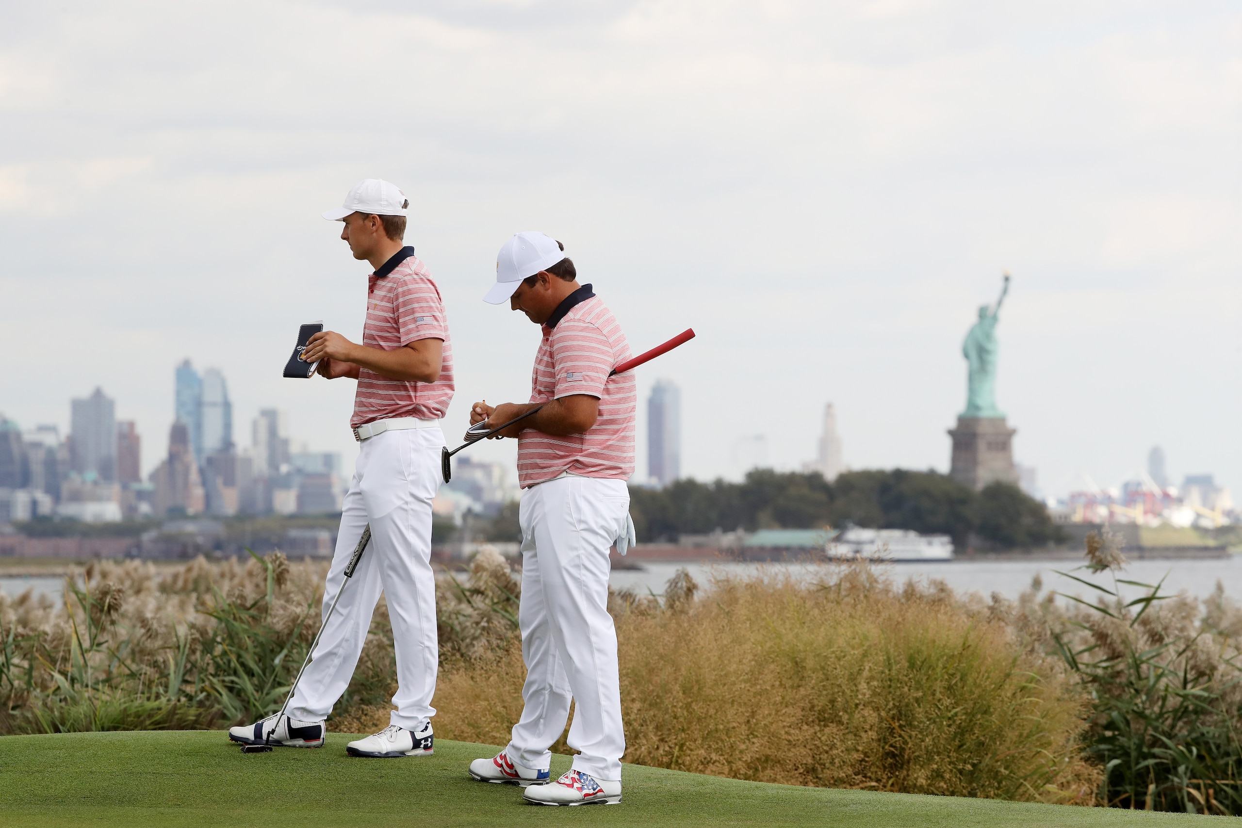 JERSEY CITY, NJ - SEPTEMBER 29:  Patrick Reed and Jordan Spieth of the U.S. Team stand on the ninth hole during Friday four-ball matches of the Presidents Cup at Liberty National Golf Club on September 29, 2017 in Jersey City, New Jersey.  (Photo by Sam G