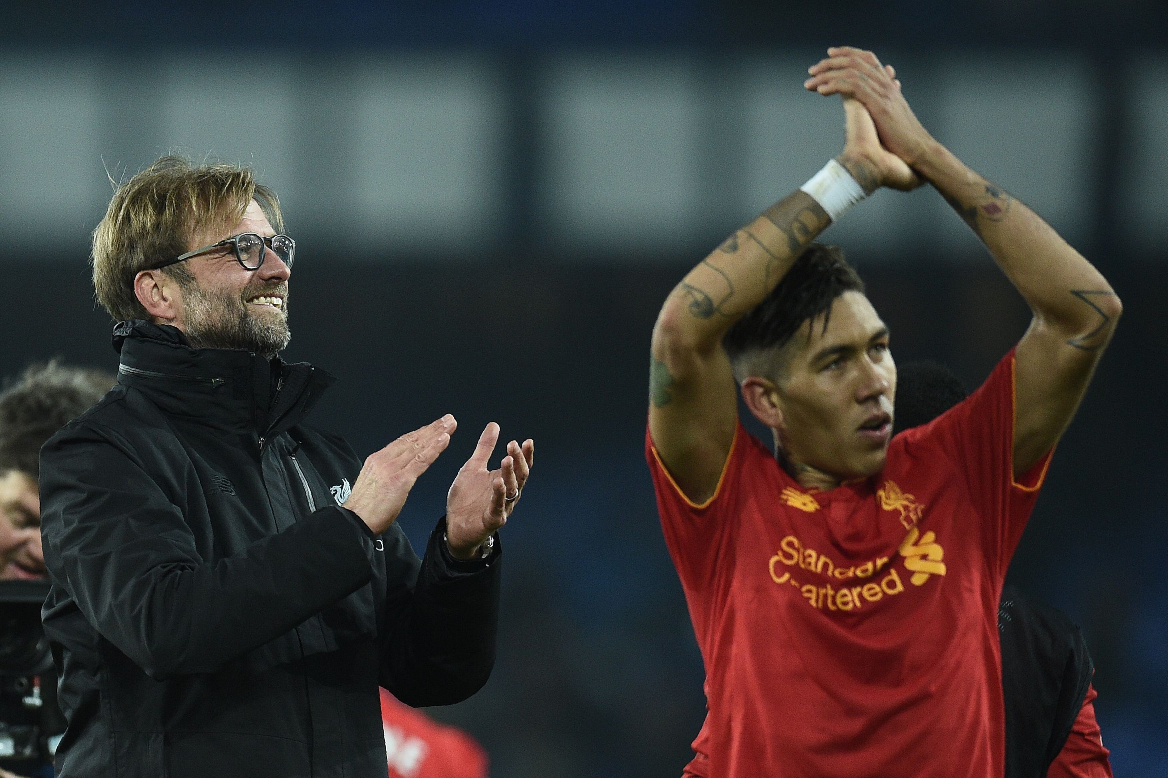 Liverpool's German manager Jurgen Klopp (L) and Liverpool's Brazilian midfielder Roberto Firmino applaud the fans following the English Premier League football match between Everton and Liverpool at Goodison Park in Liverpool, north west England on Decemb