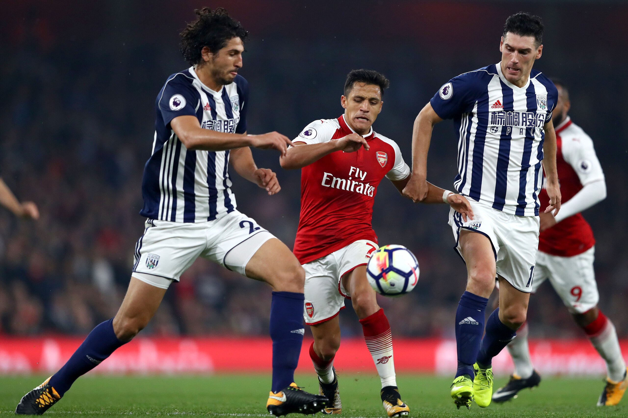 LONDON, ENGLAND - SEPTEMBER 25:  Alexis Sanchez of Arsenal takes on Ahmed El-Sayed Hegazi and Gareth Barry of West Bromwich Albion during the Premier League match between Arsenal and West Bromwich Albion at Emirates Stadium on September 25, 2017 in London