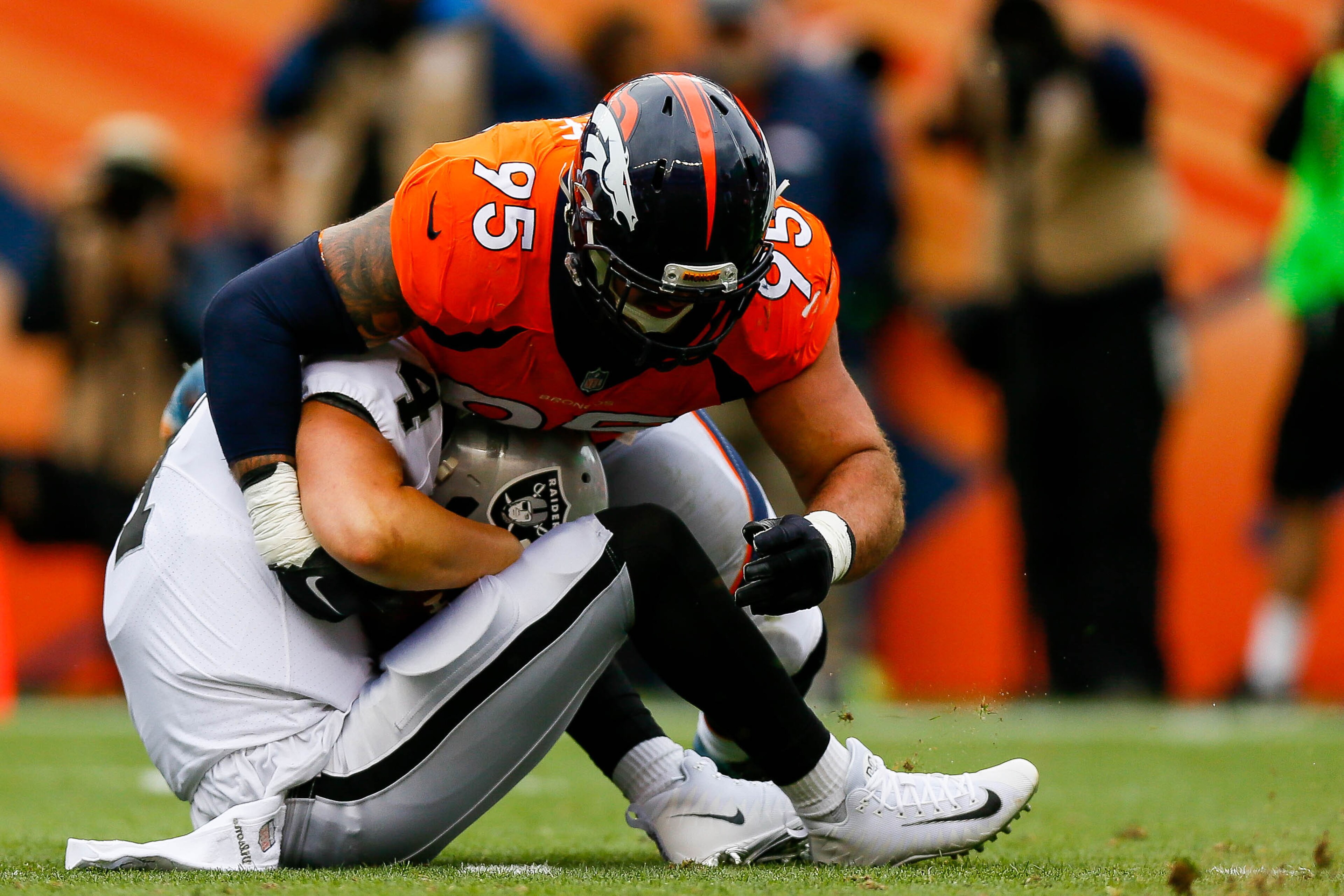 DENVER, CO - OCTOBER 1:  Defensive end Derek Wolfe #95 of the Denver Broncos sacks quarterback Derek Carr #4 of the Oakland Raiders at Sports Authority Field at Mile High on October 1, 2017 in Denver, Colorado. (Photo by Justin Edmonds/Getty Images)