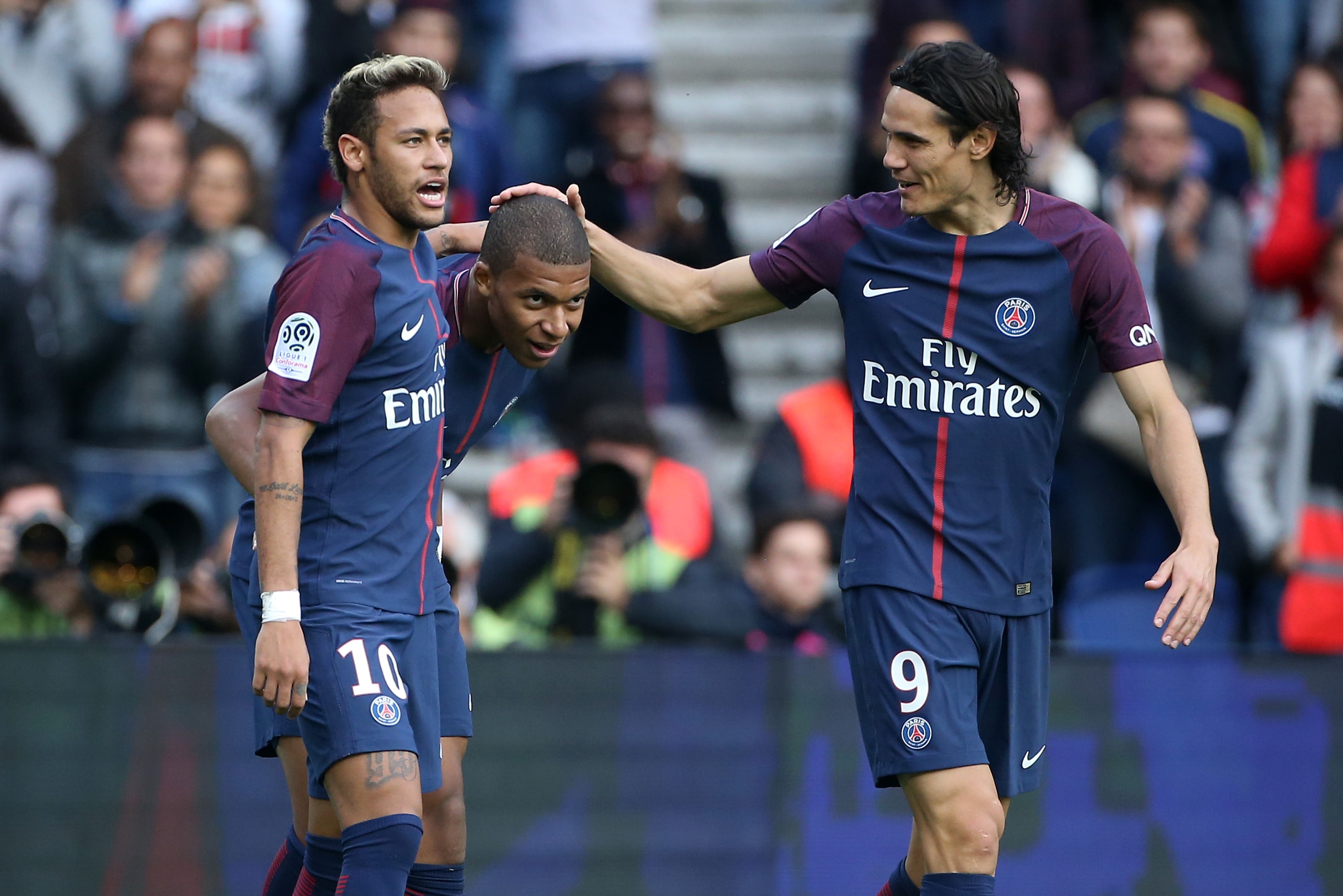 PARIS, FRANCE - SEPTEMBER 30: Kylian Mbappe of PSG celebrates his goal between Neymar Jr and Edinson Cavani during the French Ligue 1 match between Paris Saint-Germain (PSG) and FC Girondins de Bordeaux at Parc des Princes on September 30, 2017 in Paris, 