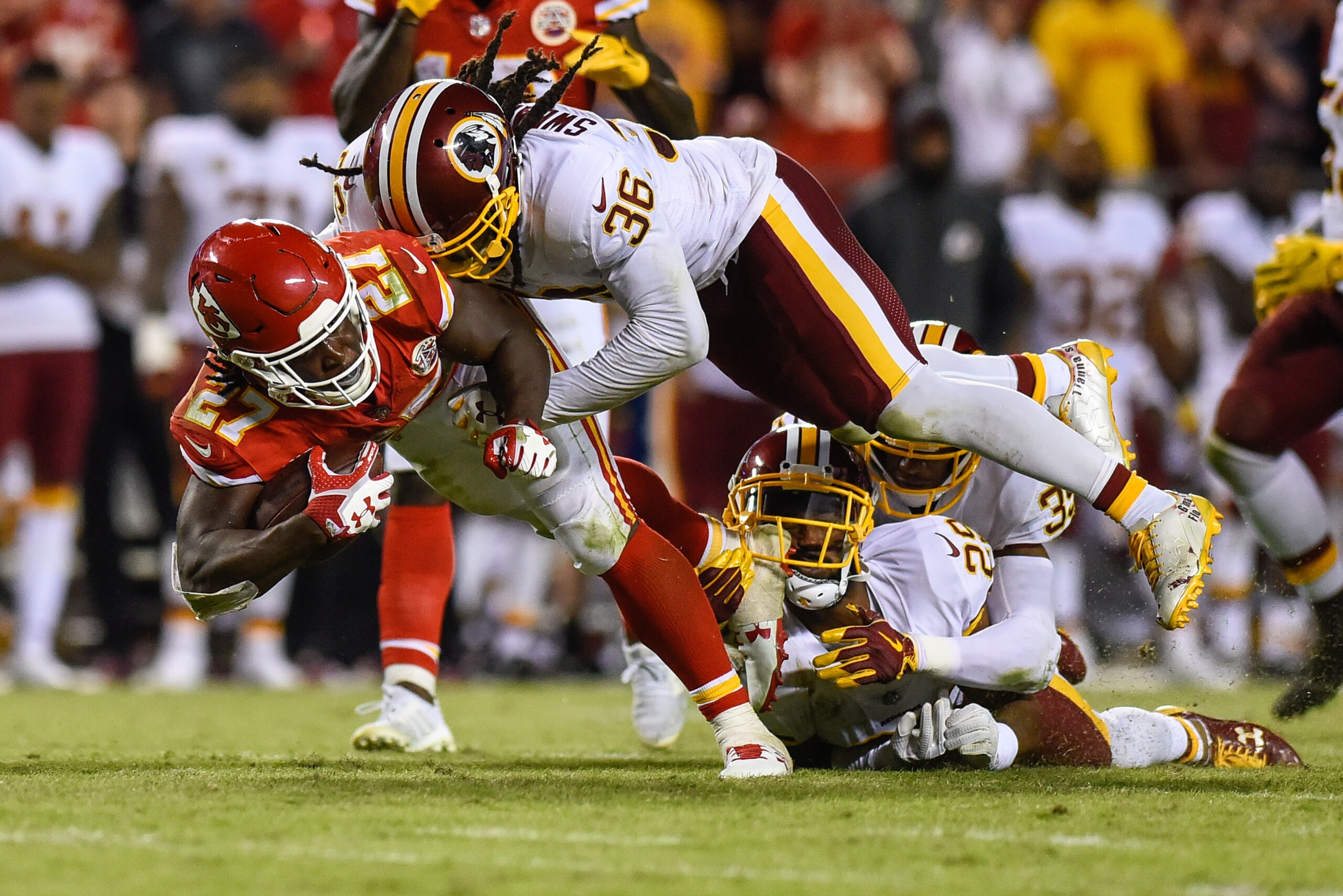 KANSAS CITY, MO - OCTOBER 2: Running back Kareem Hunt #27 of the Kansas City Chiefs is tackled by safety D.J. Swearinger #36, Keith Marshall #39, and Kendall Fuller #29 of the Washington Redskins, who got a cleat in the face, during the fourth quarter of KANSAS CITY, MO - OCTOBER 2: Running back Kareem Hunt #27 of the Kansas City Chiefs is tackled by safety D.J. Swearinger #36, Keith Marshall #39, and Kendall Fuller #29 of the Washington Redskins, who got a cleat in the face, during the fourth quarter of