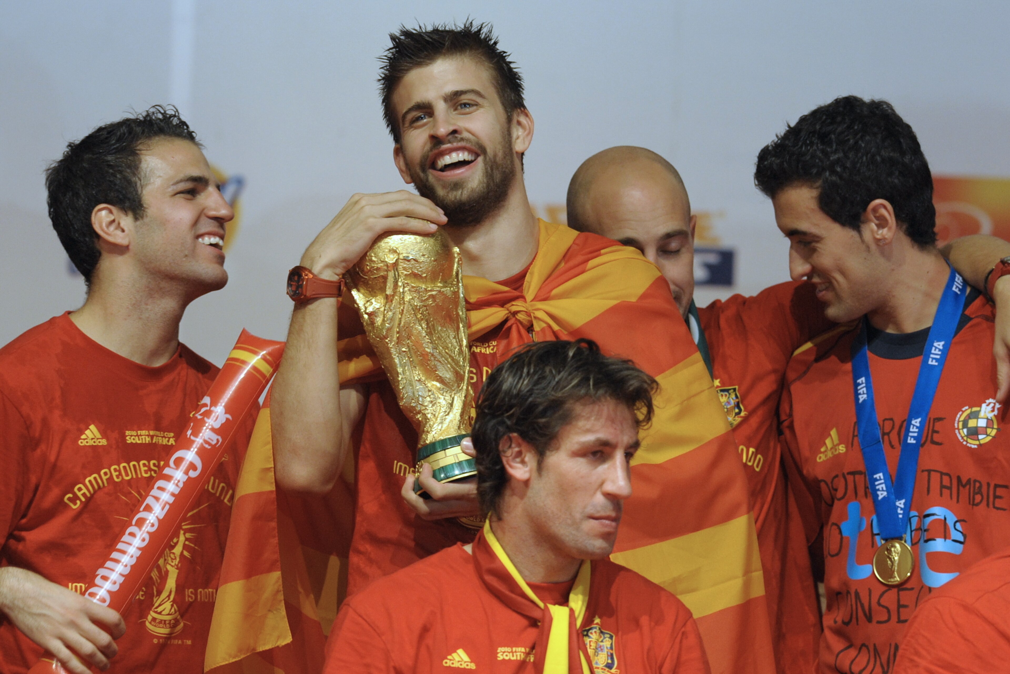 Spain's defender Gerard Pique (2ndL) hugs the trophy next to team mates on a stage set up for the Spanish team victory ceremony in Madrid on July 12, 2010 a day after they won the 2010 FIFA football World Cup match against the Netherlands in Johannesburg.