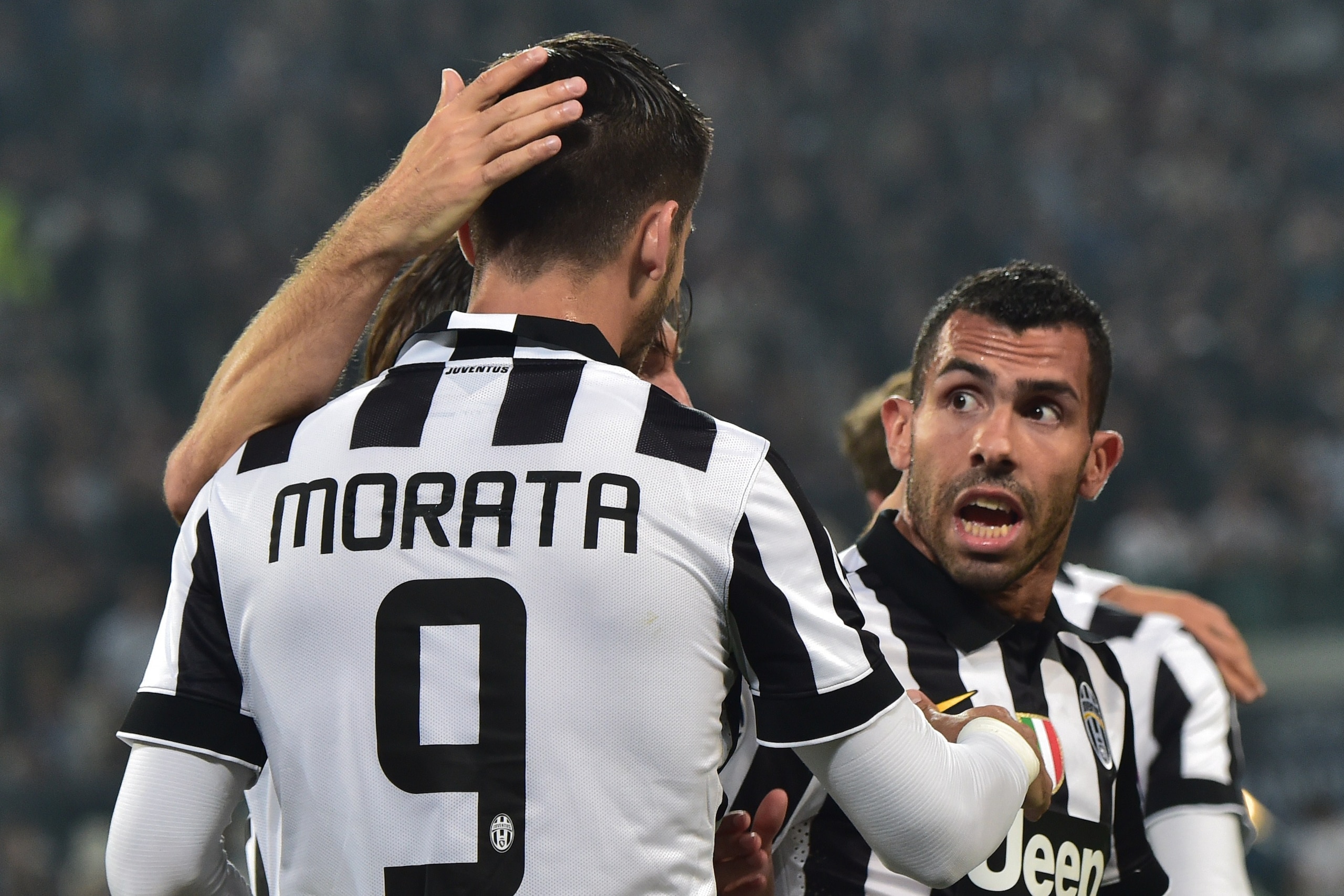 Juventus' forward from Spain Alvaro Morata is congratulated by teammates Juventus' midfielder Andrea Pirlo (hidden) and Juventus' forward from Argentina Carlos Tevez during the UEFA Champions League semi-final first leg football match Juventus vs Real Mad