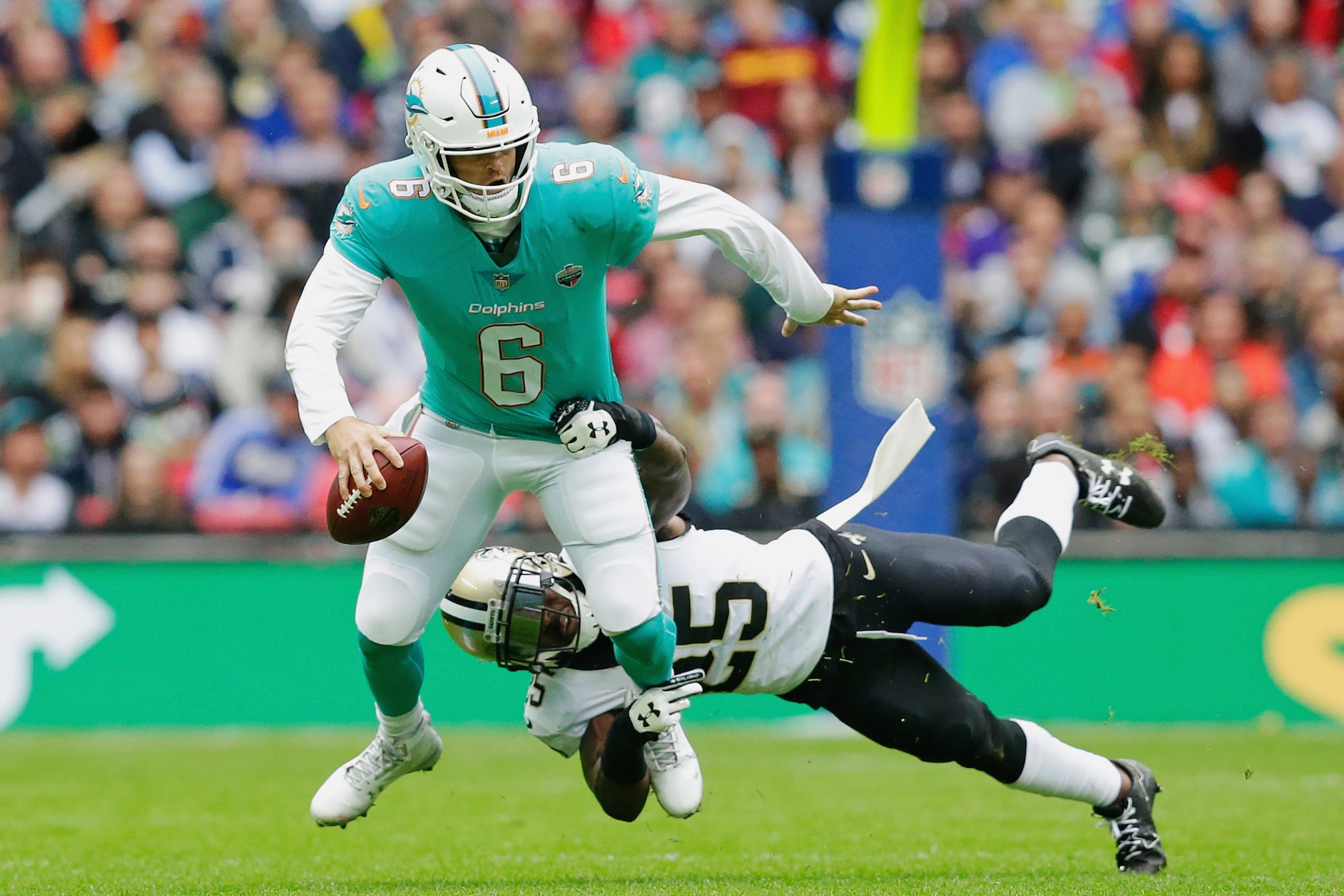 LONDON, ENGLAND - OCTOBER 01:  (Re-transmission of image #856247554) Jay Cutler #6 of the Miami Dolphins is tackled by Rafael Bush #25 of the New Orleans Saints in the first half during the NFL game between the Miami Dolphins and the New Orleans Saints at
