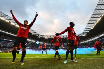 ADDING INFORMATION
Manchester United's players including Danny Wellbeck (C) celebrate Dutch striker Robin Van Persie's (L) late winning goal as English defender Rio Ferdinand (R) holds his head after being struck by an object thrown from the crowd with co