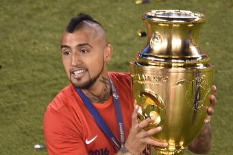 Chile's Arturo Vidal celebrates with the trophy after winning the Copa America Centenario final by defeating Argentina in the penalty shoot-out in East Rutherford, New Jersey, United States, on June 26, 2016.  / AFP / Don EMMERT        (Photo credit shoul