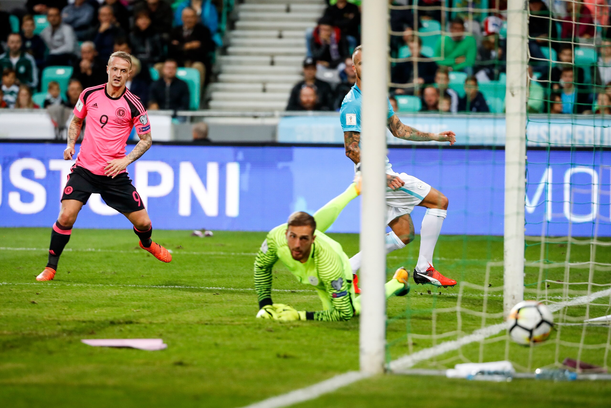 LJUBLJANA, SLOVENIA - OCTOBER 08: Leigh Griffiths (L) of Scotland scores the opening goal near goalkeeper Jan Oblak (R) of Slovenia during the FIFA 2018 World Cup Qualifier match between Slovenia and Scotland at stadium Stozice on October 08, 2017 in Ljub