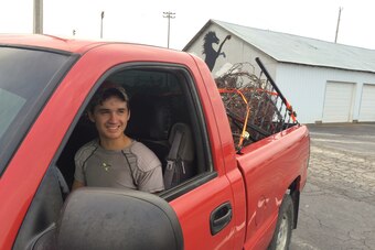 Senior Colton Loesing rides with farm equipment in the bed of his truck.