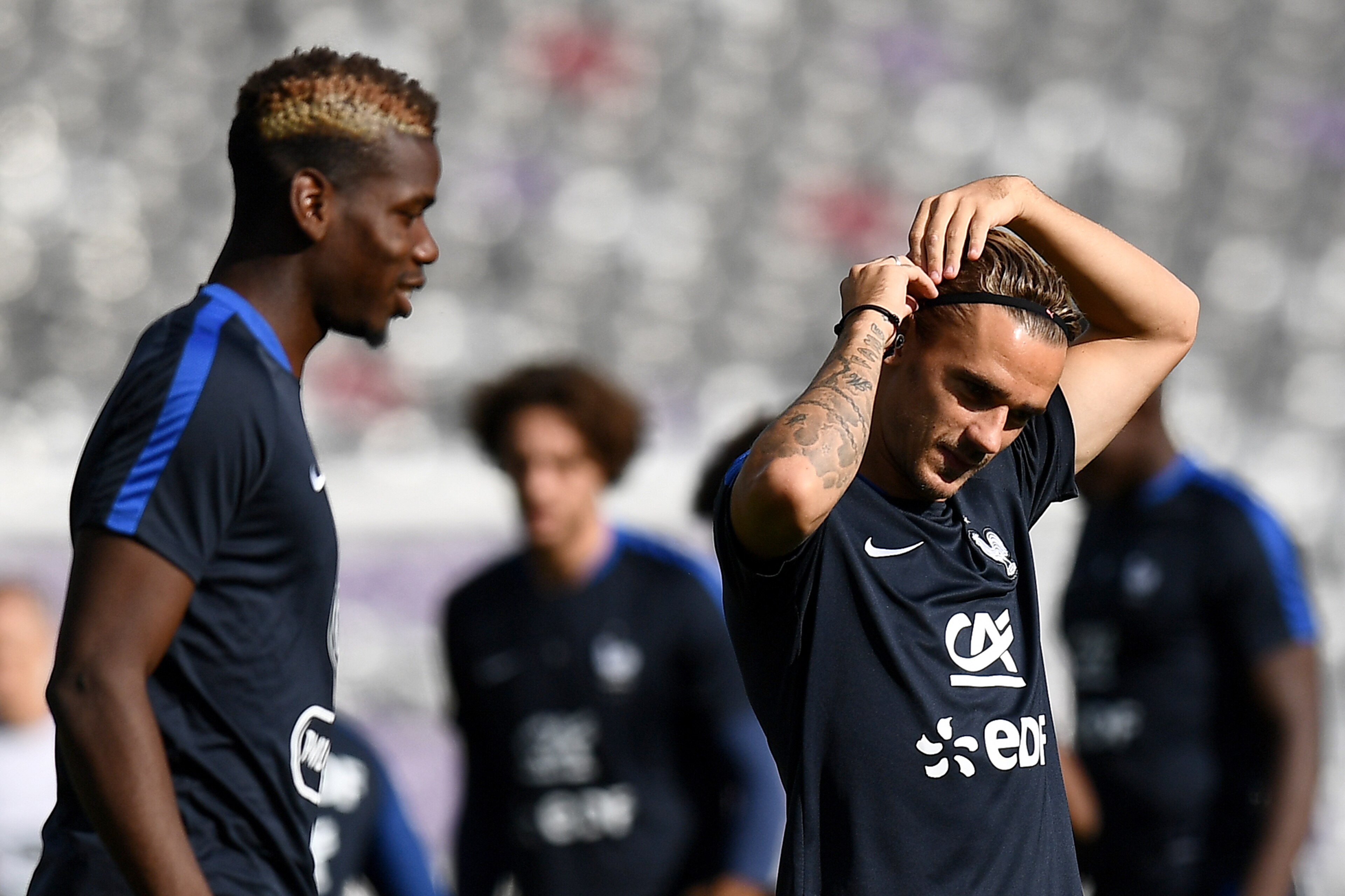 France's forward Antoine Griezmann (R) adjusts his headband next to France's midfielder Paul Pogba during a training session at the Municipal Stadium in Toulouse southern France, on September 2, 2017, on the eve of the FIFA World Cup 2018 qualifying footb