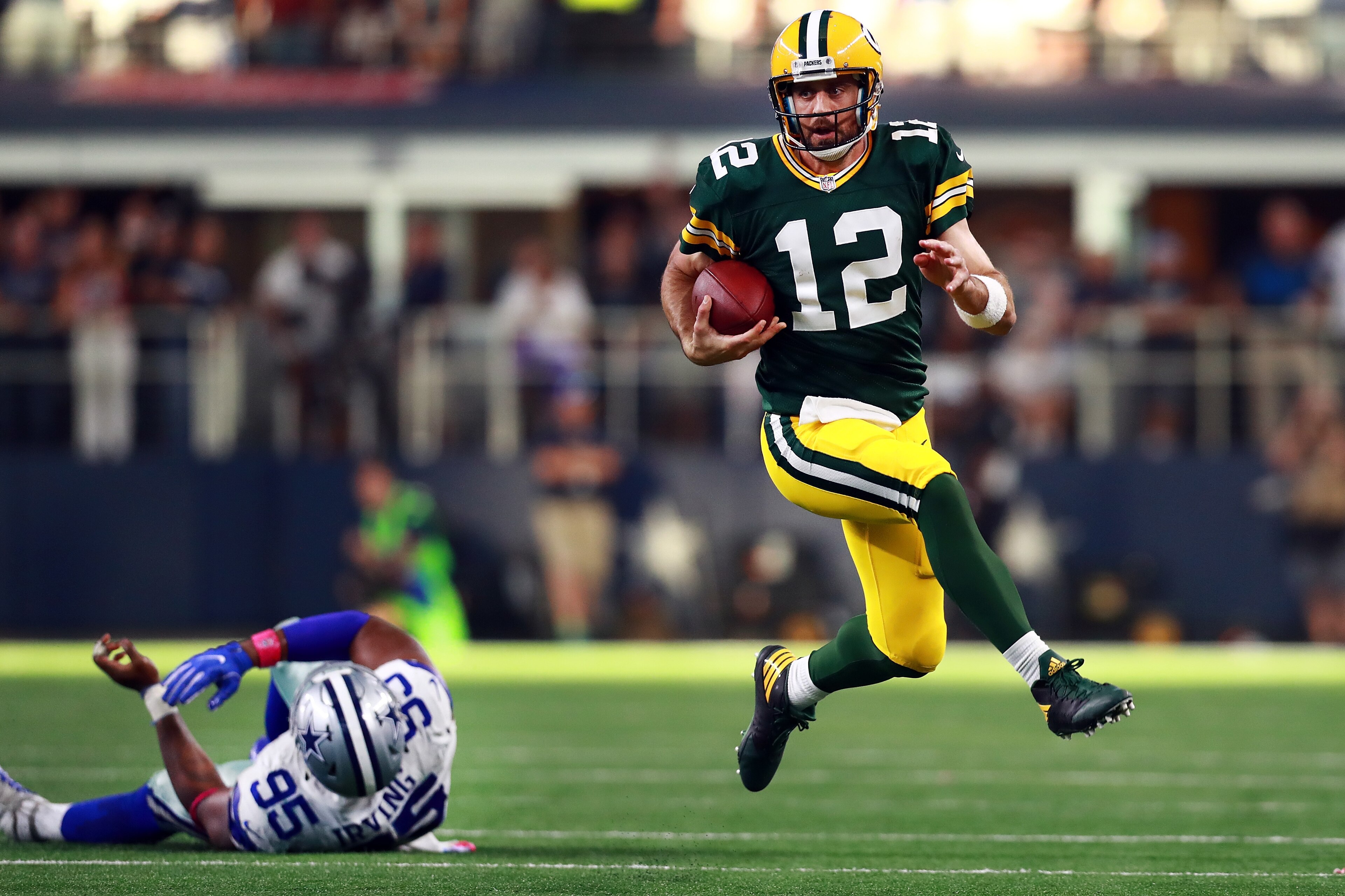 ARLINGTON, TX - OCTOBER 08:  Aaron Rodgers #12 of the Green Bay Packers scrambles with the ball against David Irving #95 of the Dallas Cowboys in the fourth quarter at AT&T Stadium on October 8, 2017 in Arlington, Texas.  (Photo by Tom Pennington/Getty Im