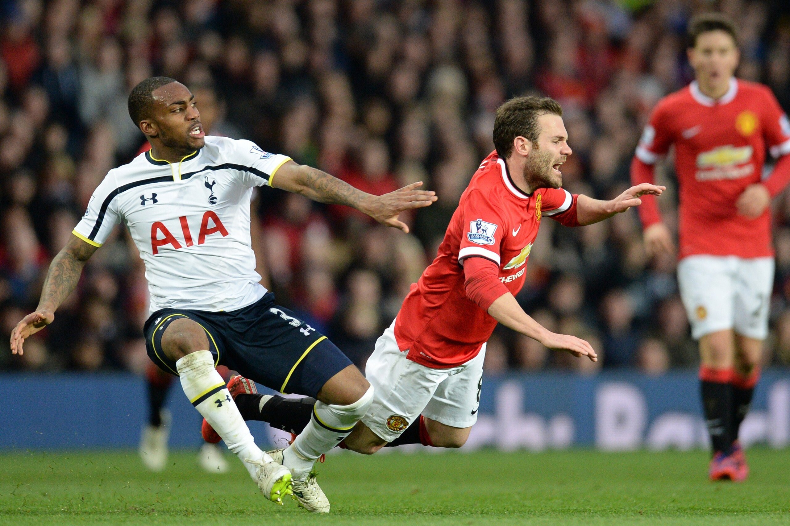 Manchester United's Spanish midfielder Juan Mata (C) is fouled by Tottenham Hotspur's English defender Danny Rose (L) during the English Premier League football match between Manchester United and Tottenham Hotspur at Old Trafford in Manchester, North Wes