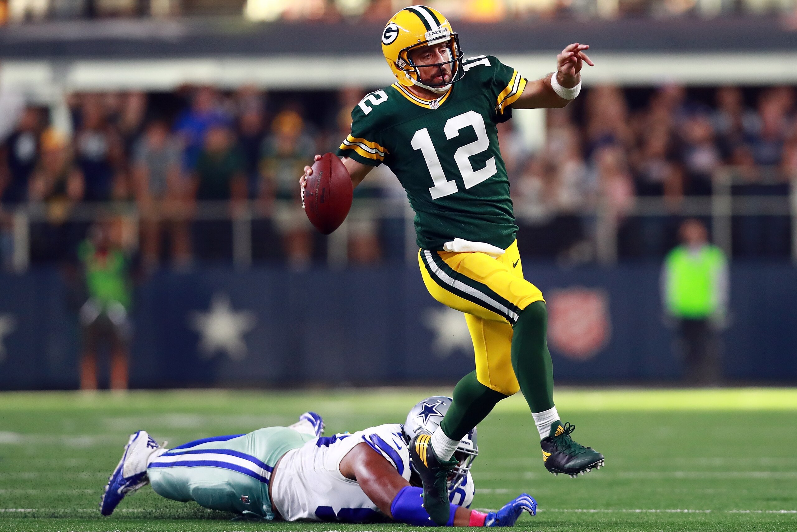 ARLINGTON, TX - OCTOBER 08:  Aaron Rodgers #12 of the Green Bay Packers scrambles with the ball against David Irving #95 of the Dallas Cowboys in the fourth quarter at AT&T Stadium on October 8, 2017 in Arlington, Texas.  (Photo by Tom Pennington/Getty Im