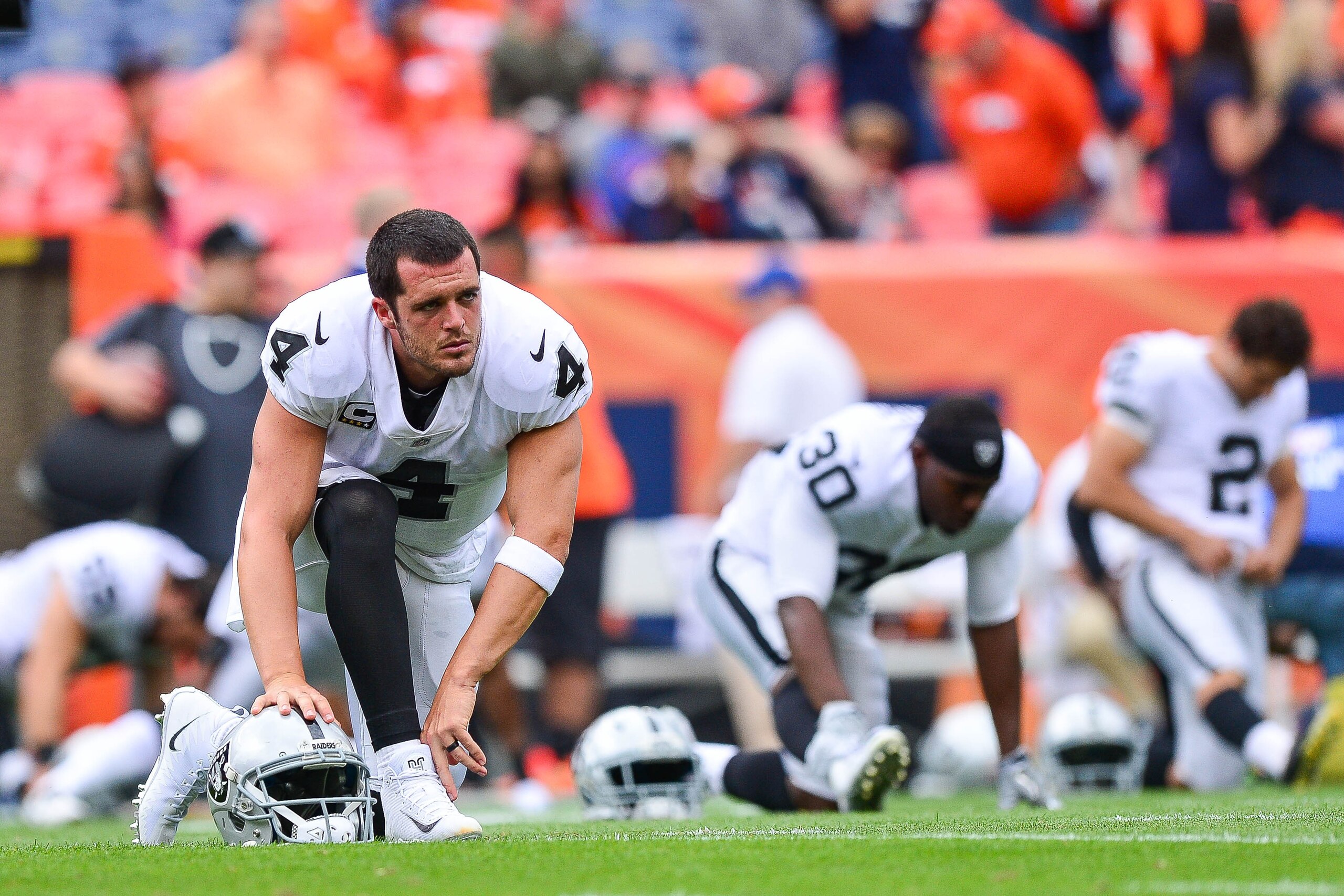 DENVER, CO - OCTOBER 1:  Quarterback  Derek Carr #4 of the Oakland Raiders stretches during player warm ups before a game against the Denver Broncos at Sports Authority Field at Mile High on October 1, 2017 in Denver, Colorado. (Photo by Dustin Bradford/G