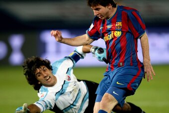 Lionel Messi of Spain's Barcelona scores past Federico Vilar of Mexico's Atlante during their FIFA Club World Cup semi-final football match in Abu Dhabi on December 16, 2009. AFP PHOTO/MARWAN NAAMANI (Photo credit should read MARWAN NAAMANI/AFP/Getty Imag