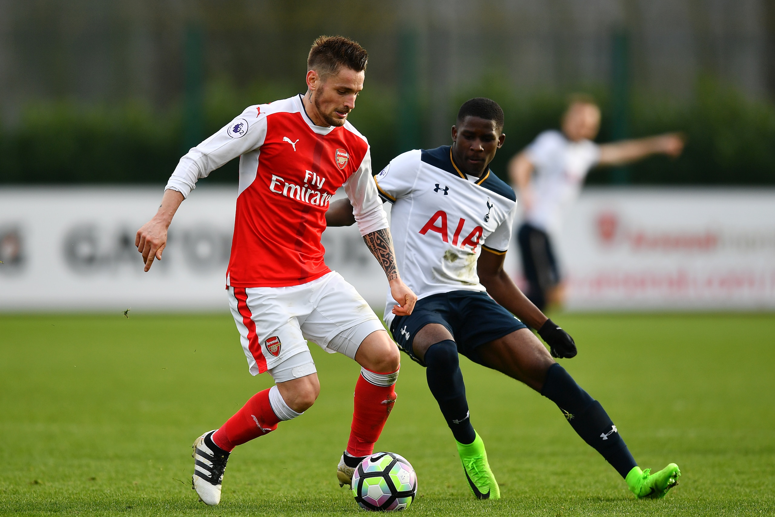 ST ALBANS, ENGLAND - MARCH 03:  Mathieu Debuchy of Arsenal holds off Shilow Tracey of Tottenham Hotspur during the Premier League 2 match between Arsenal and Tottenham Hotspur at London Colney on March 3, 2017 in St Albans, England. (Photo by Dan Mullan/G