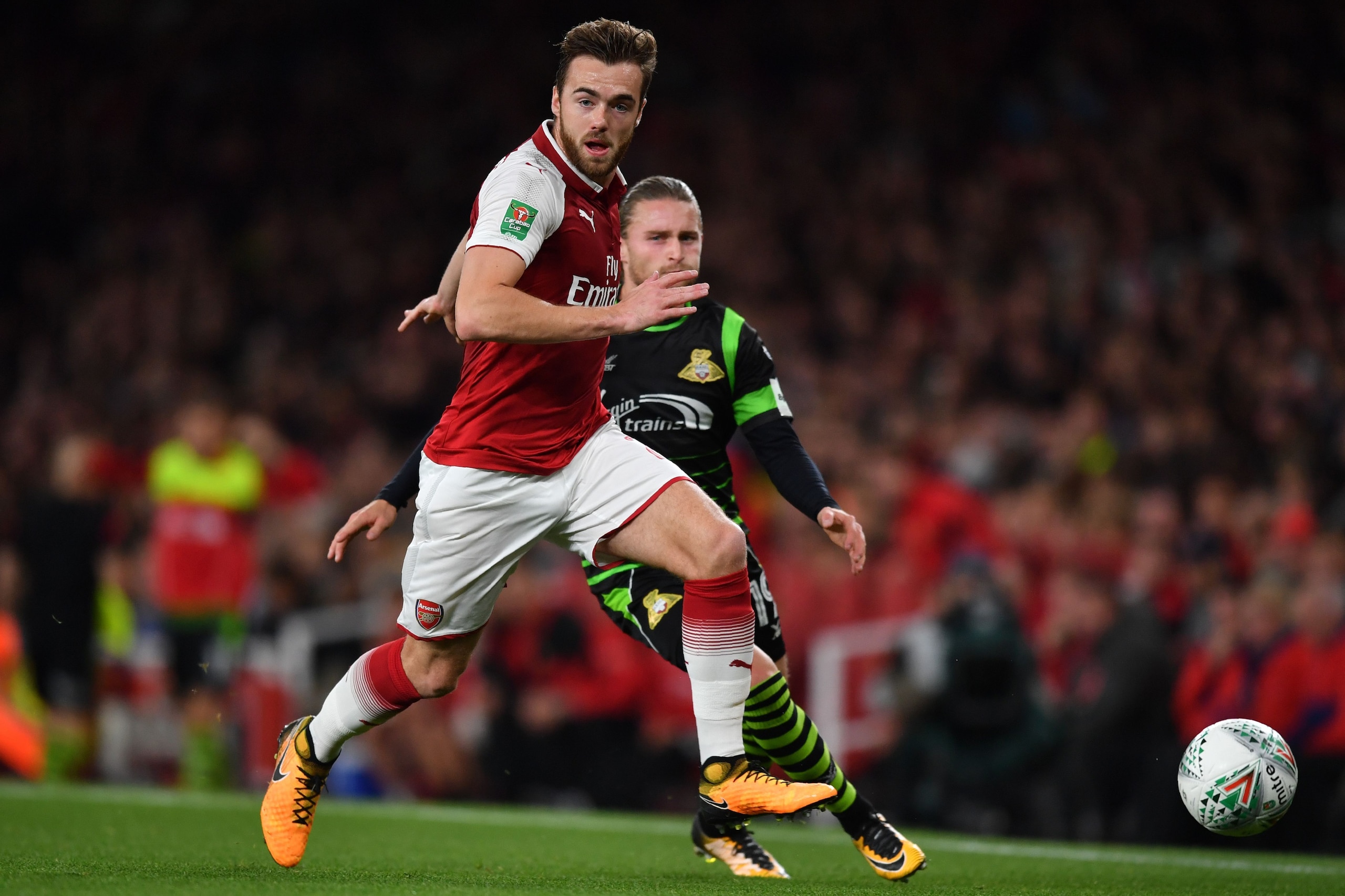 Arsenal's English defender Calum Chambers runs away from Doncaster Rovers' English striker Alfie May during the English League Cup third round football match between Arsenal and Doncaster Rovers at The Emirates Stadium in London on September 20, 2017. / A