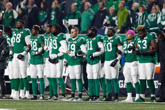 REGINA, SK - OCTOBER 13: Members of the Saskatchewan Roughriders link arms during the national anthem in a show of unity with NFL players before  the game between the Ottawa Redblacks and Saskatchewan Roughriders at Mosaic Stadium on October 13, 2017 in R