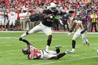 GLENDALE, AZ - OCTOBER 15:  Adrian Peterson #23 of the Arizona Cardinals leaps over a tackle by Vernon Hargreaves III #28 of the Tampa Bay Buccaneers during the second quarter at University of Phoenix Stadium on October 15, 2017 in Glendale, Arizona.  (Ph
