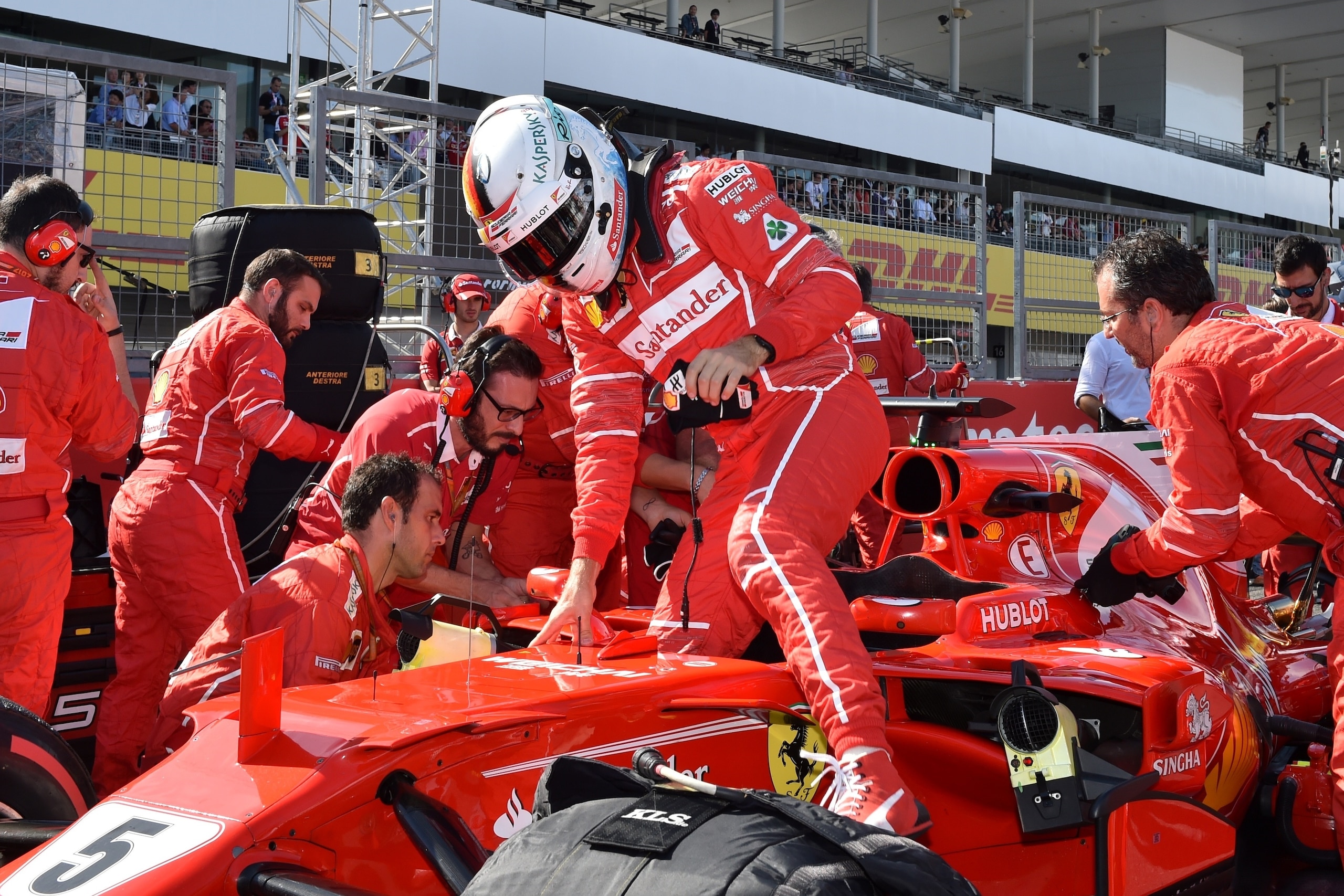 Ferrari's German driver Sebastian Vettel (C) gets out of his car before the start of the Formula One Japanese Grand Prix at Suzuka on October 8, 2017.  / AFP PHOTO / Kazuhiro NOGI        (Photo credit should read KAZUHIRO NOGI/AFP/Getty Images)