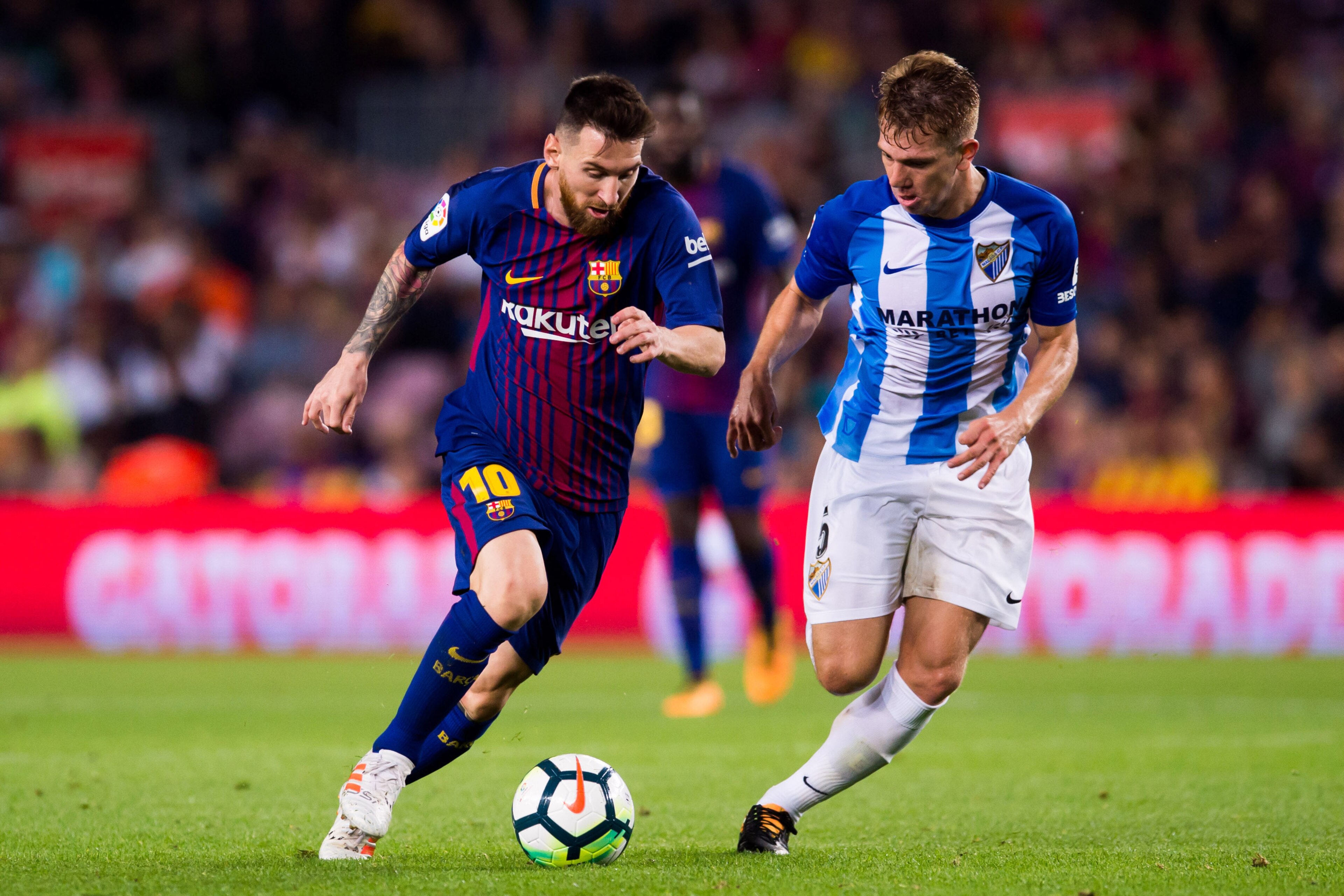 BARCELONA, SPAIN - OCTOBER 21:  Lionel Messi of FC Barcelona controls the ball under pressure from Esteban Rolon of Malaga CF during the La Liga match between Barcelona and Malaga at Camp Nou on October 21, 2017 in Barcelona, Spain.  (Photo by Alex Caparr