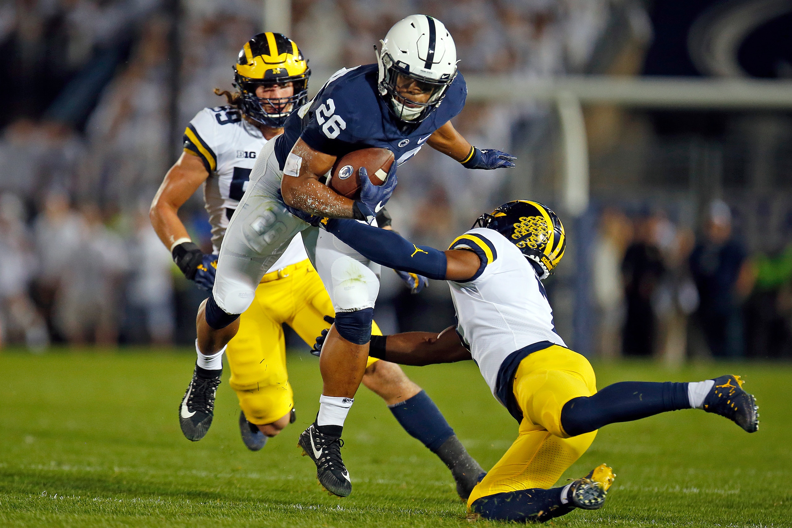 STATE COLLEGE, PA - OCTOBER 21:  Saquon Barkley #26 of the Penn State Nittany Lions runs after making a catch in the first half against Khaleke Hudson #7 and Noah Furbush #59 of the Michigan Wolverines on October 21, 2017 at Beaver Stadium in State Colleg