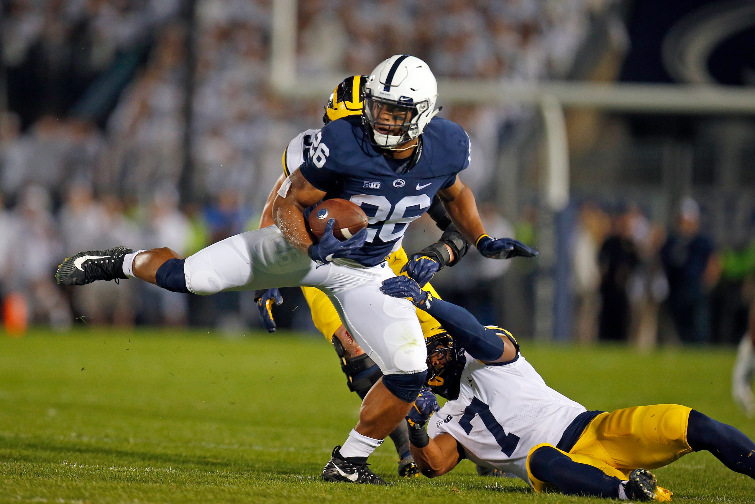 STATE COLLEGE, PA - OCTOBER 21:  Saquon Barkley #26 of the Penn State Nittany Lions runs after making a catch in the first half against Khaleke Hudson #7 and Noah Furbush #59 of the Michigan Wolverines on October 21, 2017 at Beaver Stadium in State Colleg