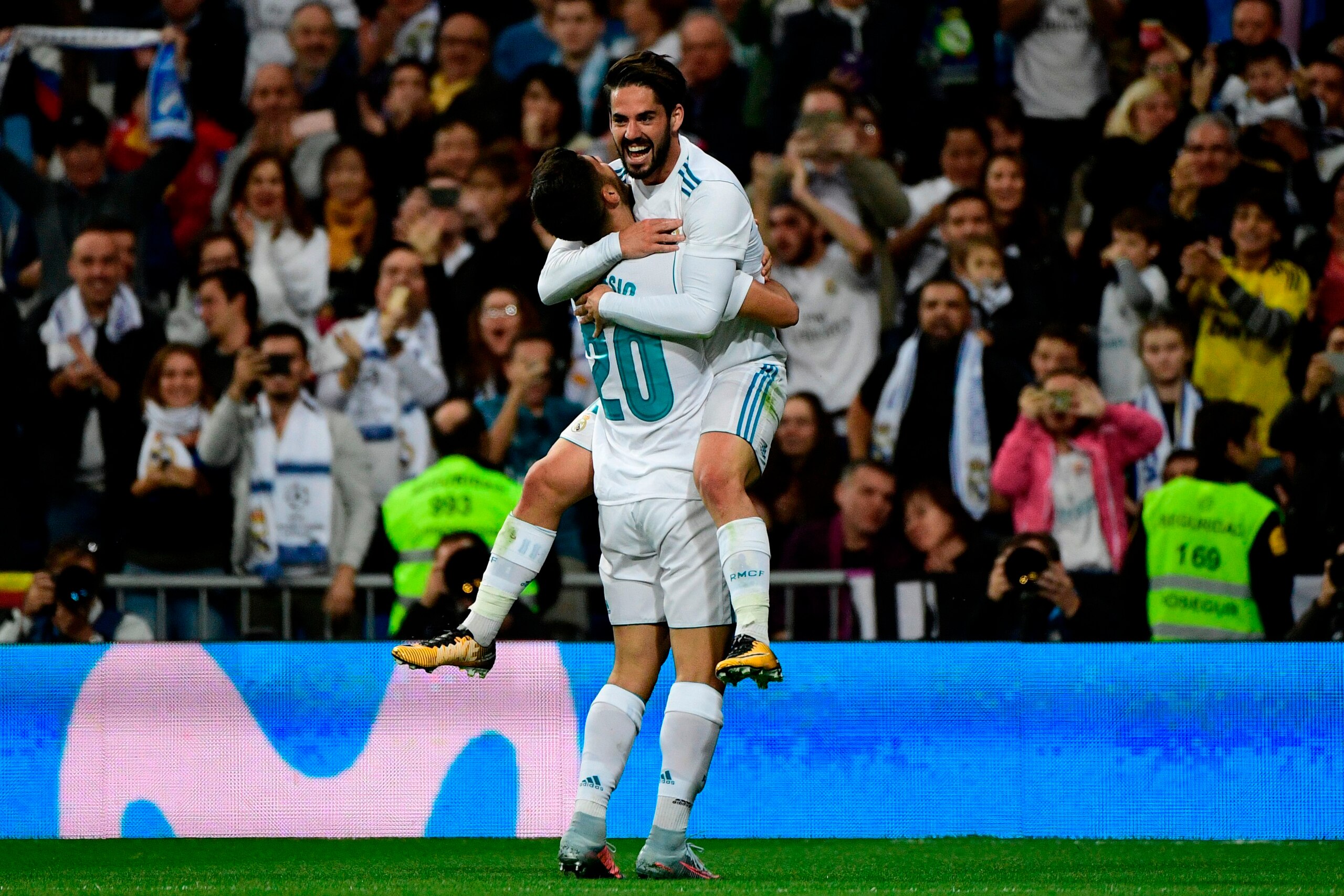 Real Madrid's Spanish midfielder Marco Asensio (L) celebrates with Real Madrid's Spanish midfielder Isco after scoring a goal during the Spanish league football match Real Madrid CF vs SD Eibar at the Santiago Bernabeu stadium in Madrid on October 22, 201