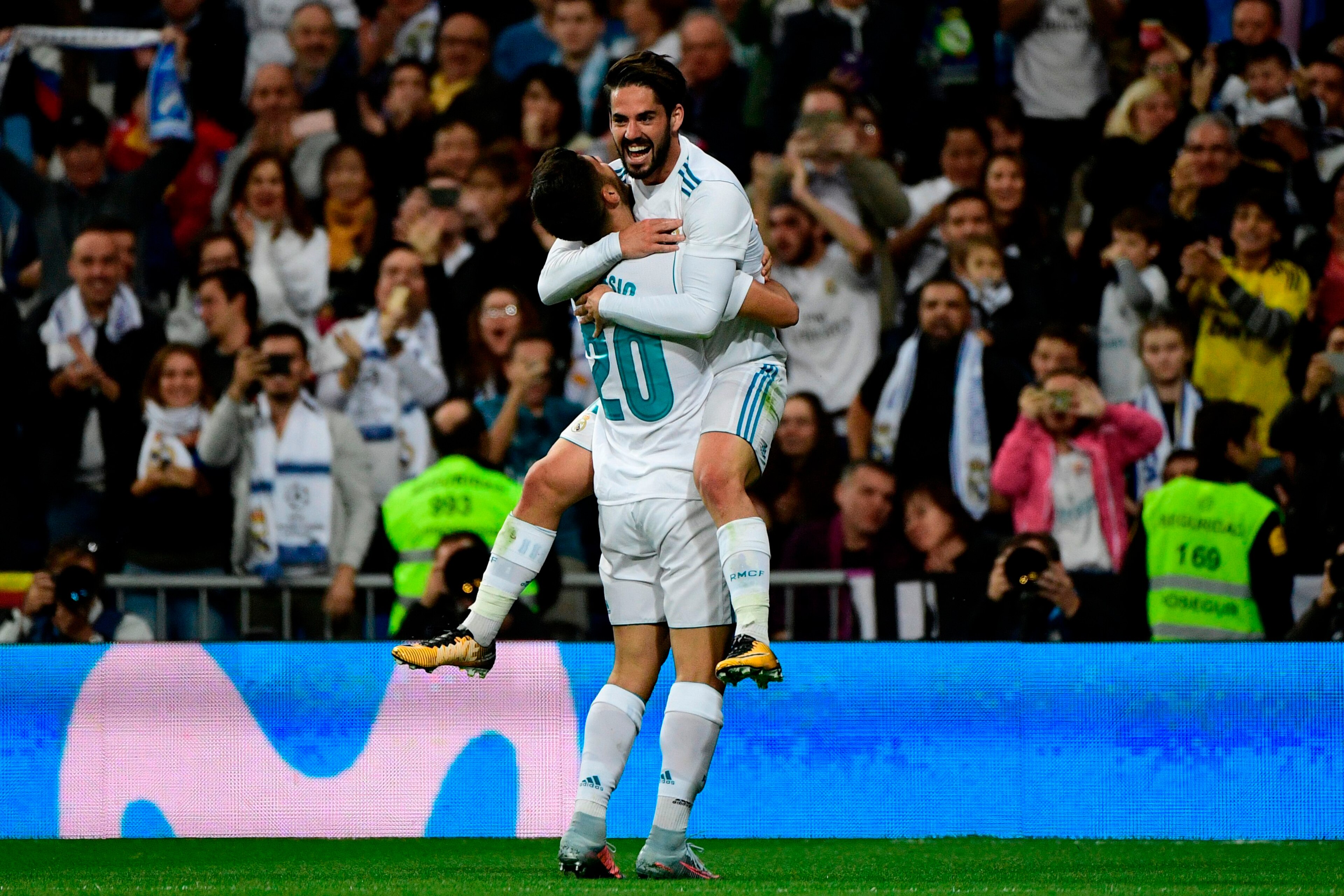 Real Madrid's Spanish midfielder Marco Asensio (L) celebrates with Real Madrid's Spanish midfielder Isco after scoring a goal during the Spanish league football match Real Madrid CF vs SD Eibar at the Santiago Bernabeu stadium in Madrid on October 22, 201
