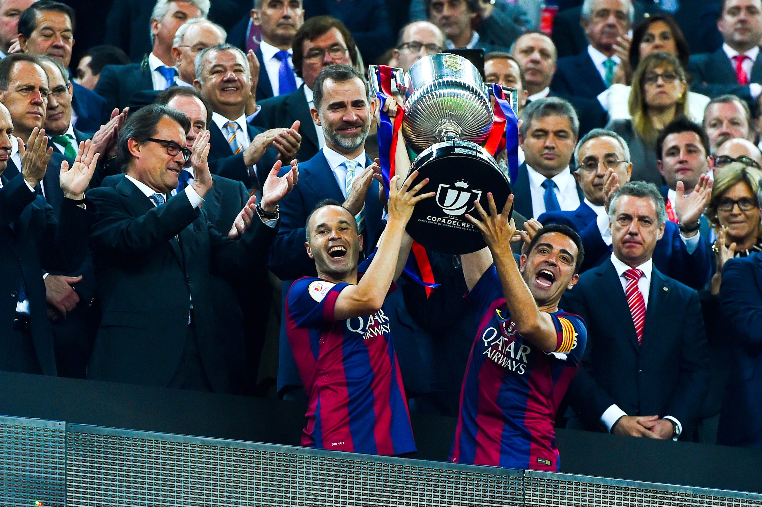 BARCELONA, SPAIN - MAY 30:  FC Barcelona players Andres Iniesta (L) and Xavi Hernandez of FC Barcelona celebrate with the trophy after winning the Copa del Rey Final match between FC Barcelona and Athletic Club at Camp Nou on May 30, 2015 in Barcelona, Sp