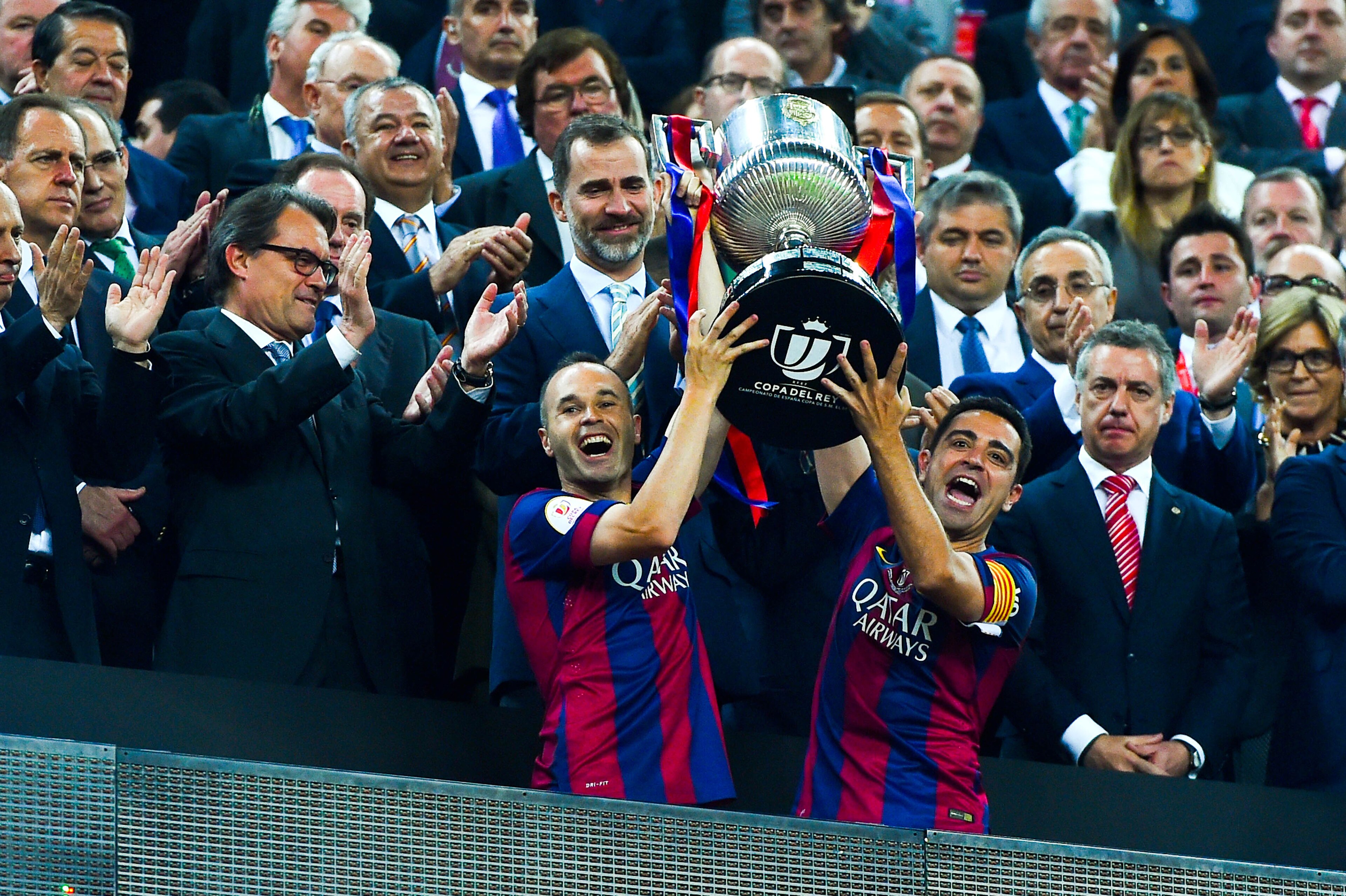 BARCELONA, SPAIN - MAY 30:  FC Barcelona players Andres Iniesta (L) and Xavi Hernandez of FC Barcelona celebrate with the trophy after winning the Copa del Rey Final match between FC Barcelona and Athletic Club at Camp Nou on May 30, 2015 in Barcelona, Sp