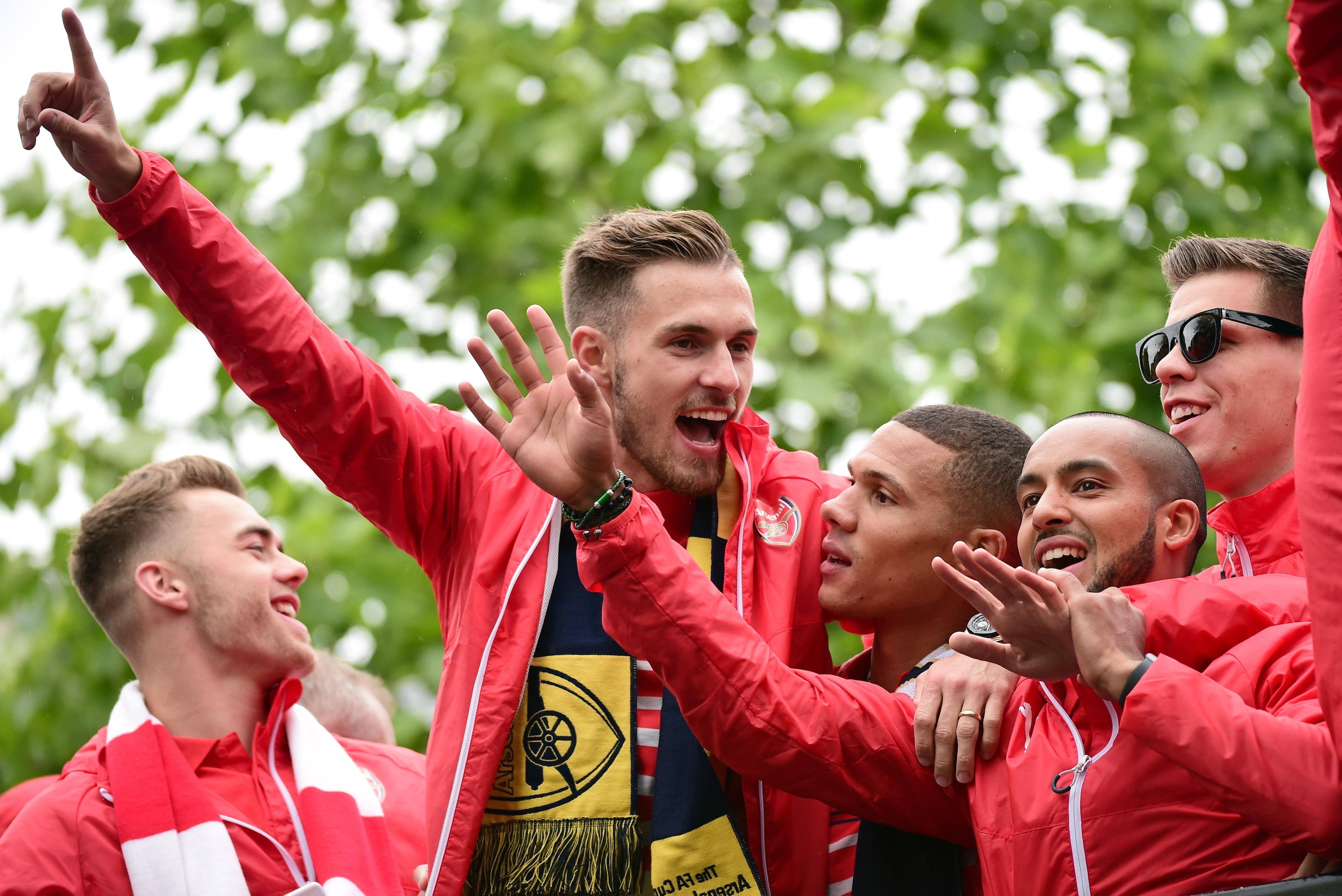 Arsenal's Welsh midfielder Aaron Ramsey (2L) getures to the fans as he stands with teammates on the top deck of an open-topped bus during the Arsenal victory parade in London on May 31, 2015, following their win in the English FA Cup final football match 