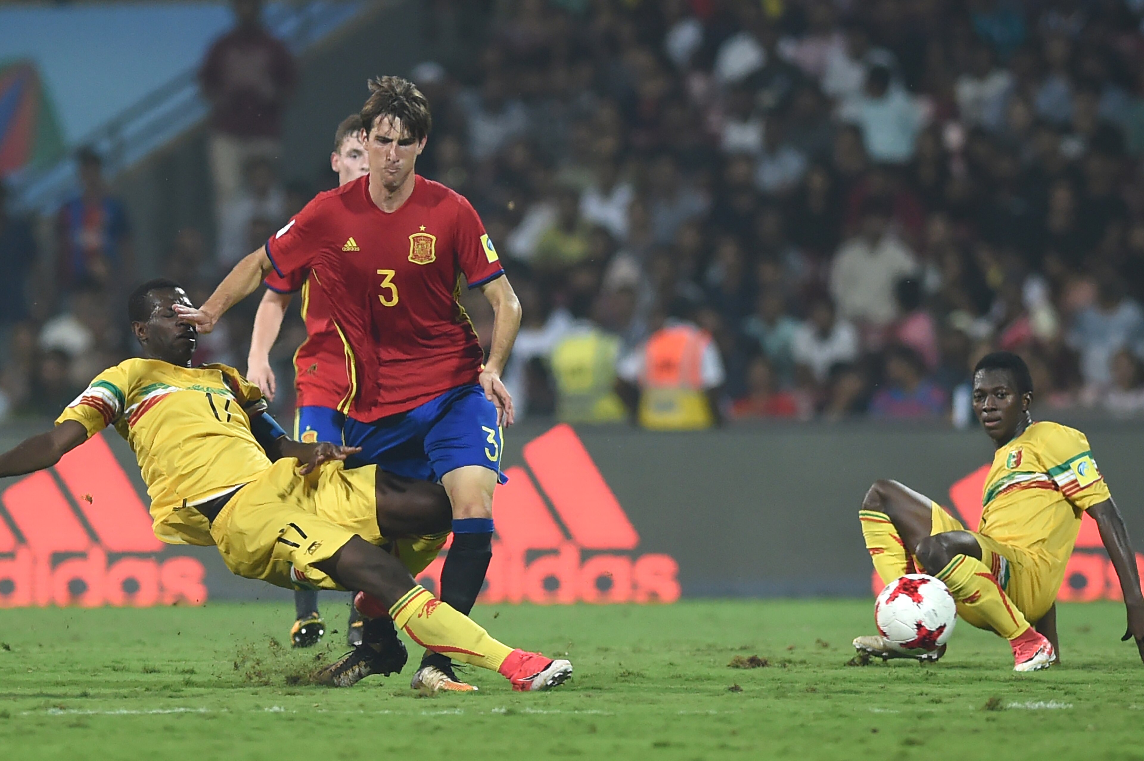 Juan Miranda of Spain (C) and Mamadou Samake (L) of Mali vie for the ball during the second semi final football match between Mali and Spain in the FIFA U-17 World Cup at the D.Y.Patil stadium in Navi Mumbai on October 25, 2017. / AFP PHOTO / PUNIT PARANJ