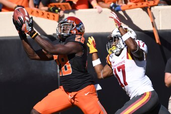 STILLWATER, OK - OCTOBER 8: Wide receiver James Washington #28 of the Oklahoma State Cowboys grabs a pass as he outruns defensive back Jomal Wiltz of the Iowa State Cyclones during the first half of a NCAA football game at Boone Pickens Stadium on October