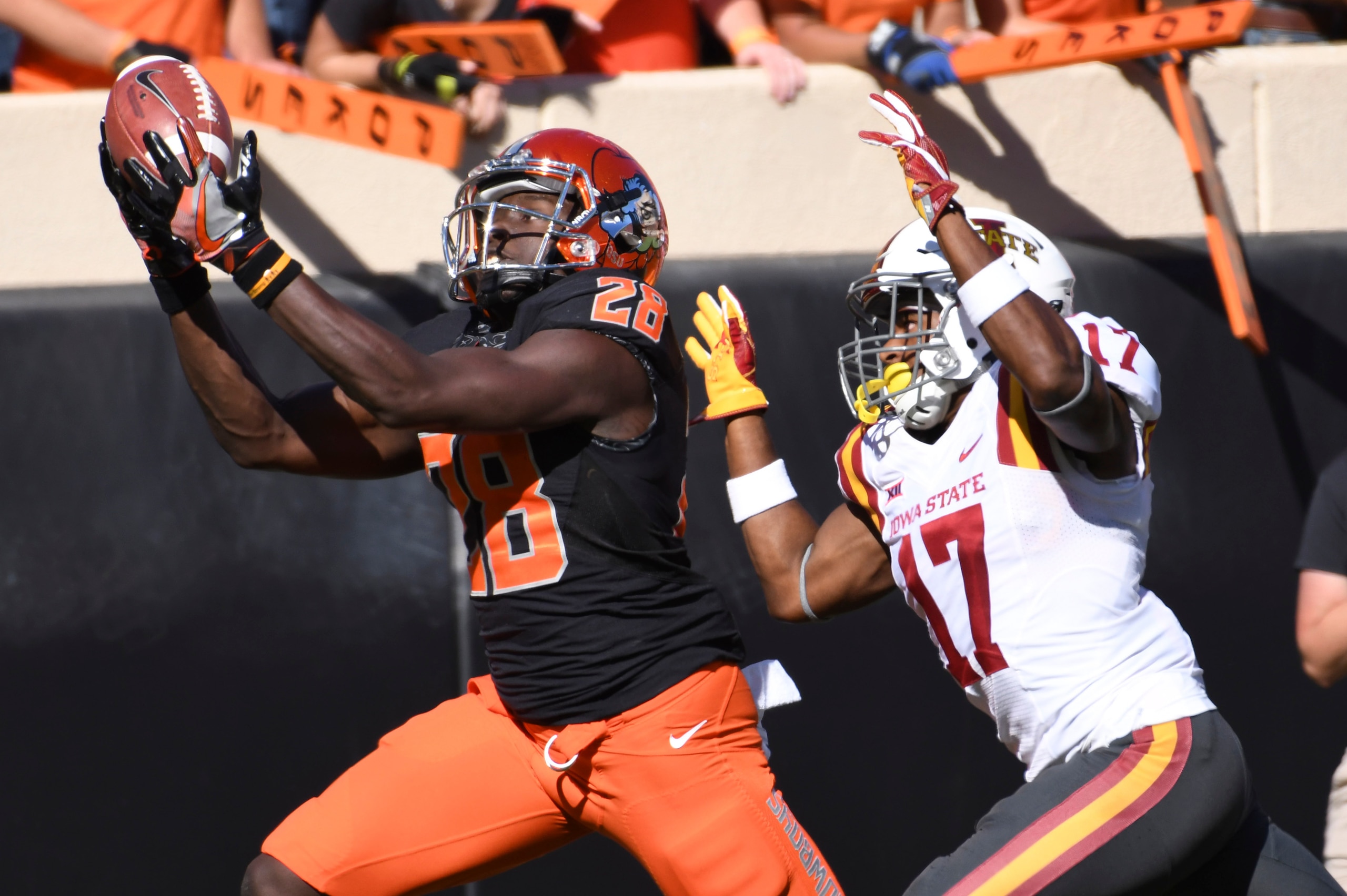 STILLWATER, OK - OCTOBER 8: Wide receiver James Washington #28 of the Oklahoma State Cowboys grabs a pass as he outruns defensive back Jomal Wiltz of the Iowa State Cyclones during the first half of a NCAA football game at Boone Pickens Stadium on October