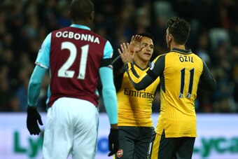LONDON, ENGLAND - DECEMBER 03:  Mesut Oezil of Arsenal celebrates with team-mate Alexis Sanchez after scoring the opening goal during the Premier League match between West Ham United and Arsenal at London Stadium on December 3, 2016 in London, England.  (