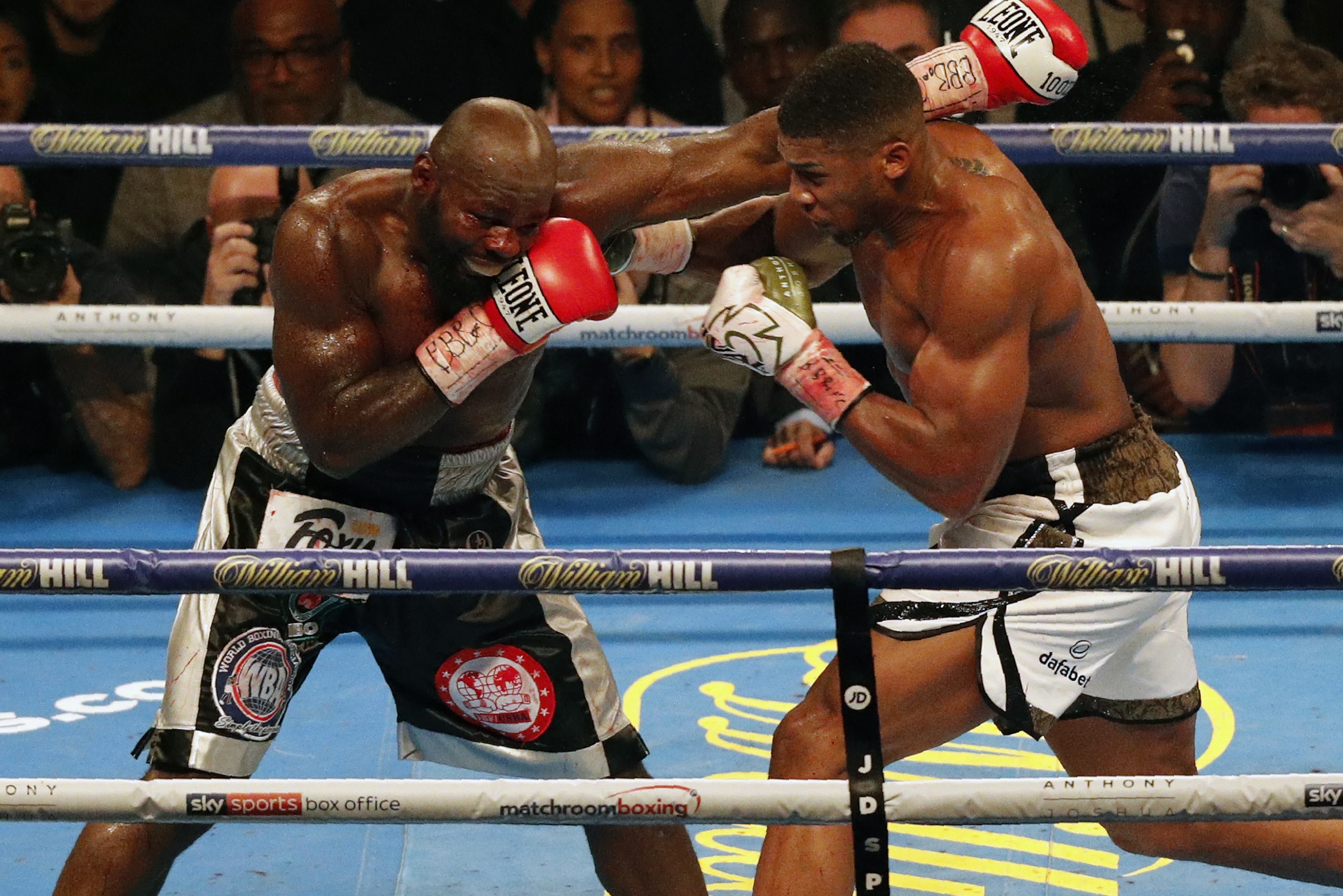 Cameroon-born Carlos Takam (L) exchanges blows with Britain's Anthony Joshua (R) during their world heavyweight title fight at The Principality Stadium in Cardiff on October 28, 2017.
Joshua stopped Takam in 10th round to retain his championship belts.  /