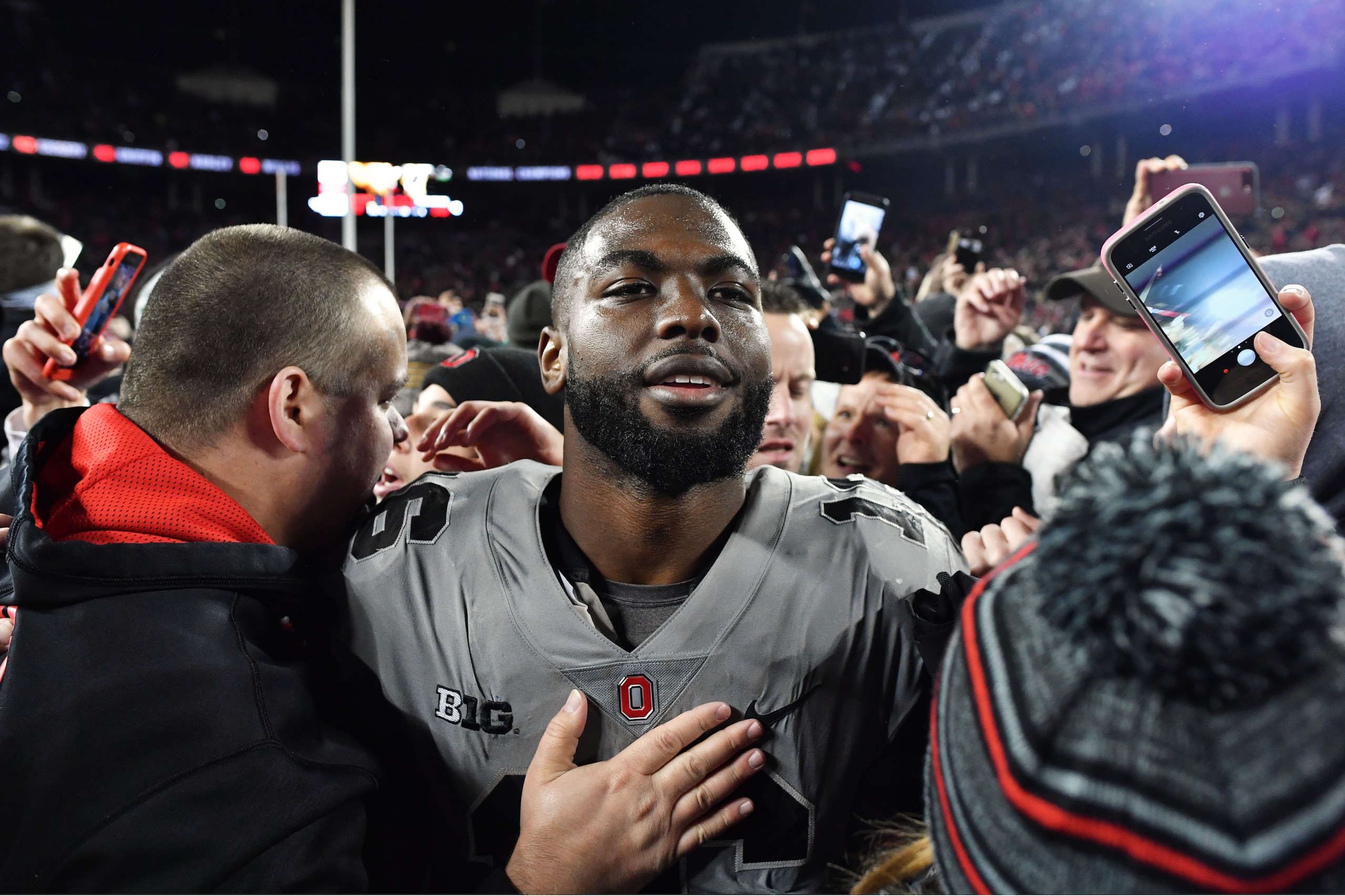 COLUMBUS, OH - OCTOBER 28:  J.T. Barrett #16 of the Ohio State Buckeyes is surrounded by fans as he walks off the field after defeating Penn State 39-38 at Ohio Stadium on October 28, 2017 in Columbus, Ohio.  (Photo by Jamie Sabau/Getty Images)