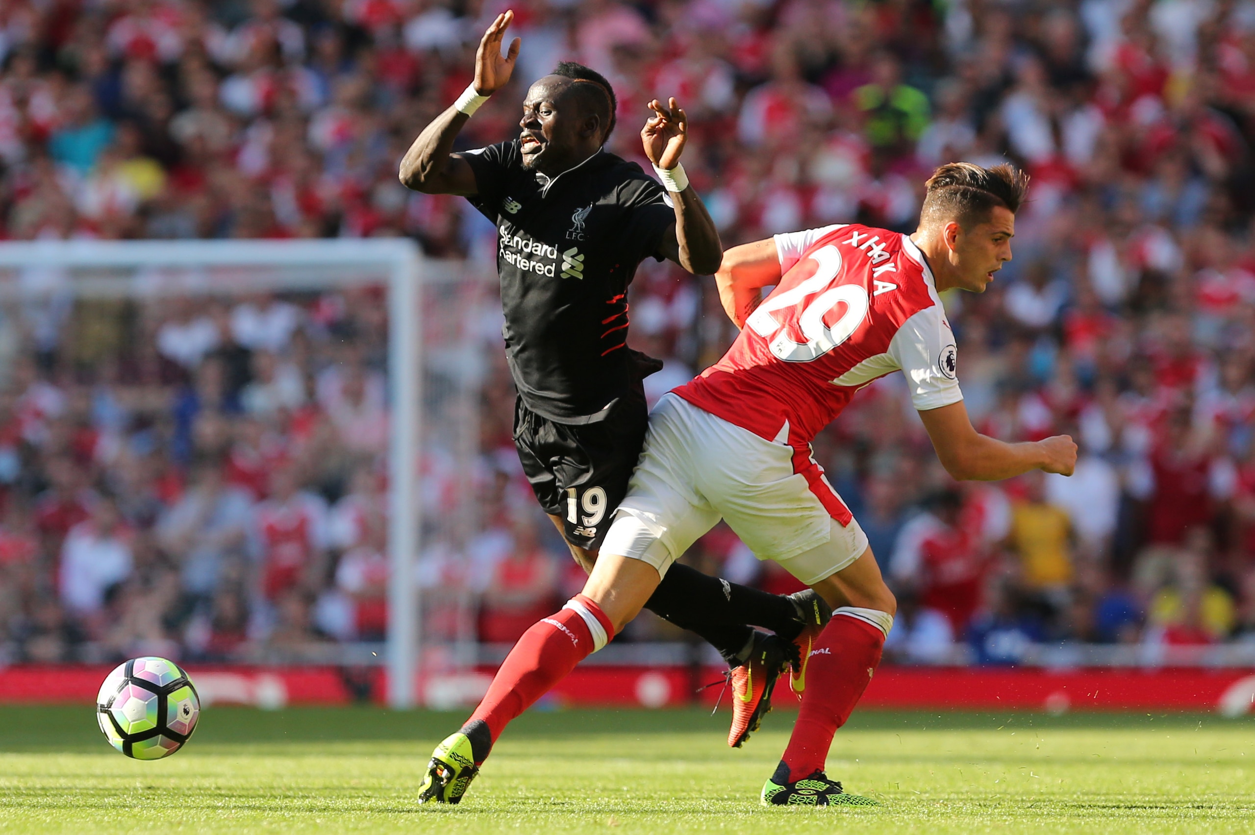 Arsenal's Swiss midfielder Granit Xhaka (R) challenges Liverpool's Senegalese midfielder Sadio Mane (L) during the English Premier League football match between Arsenal and Liverpool at the Emirates Stadium in London on August 14, 2016.  / AFP / Lee MILLS
