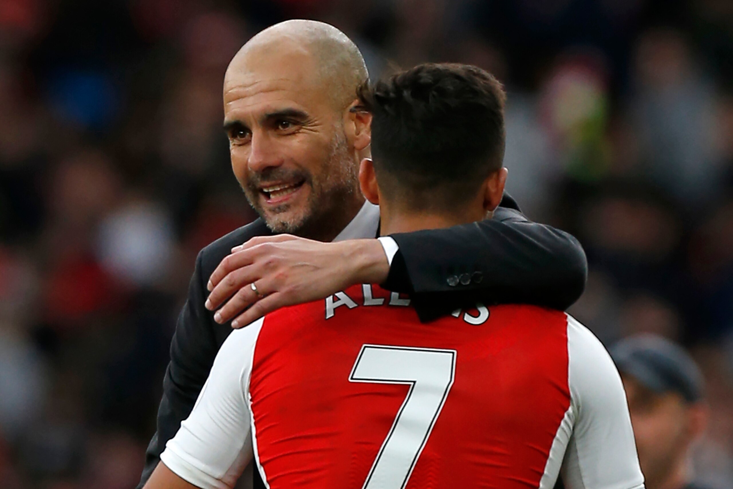 Manchester City's Spanish manager Pep Guardiola embraces Arsenal's Chilean striker Alexis Sanchez on the pitch after the English Premier League football match between Arsenal and Manchester City at The Emirates in London, on April 2, 2017.
The game finish