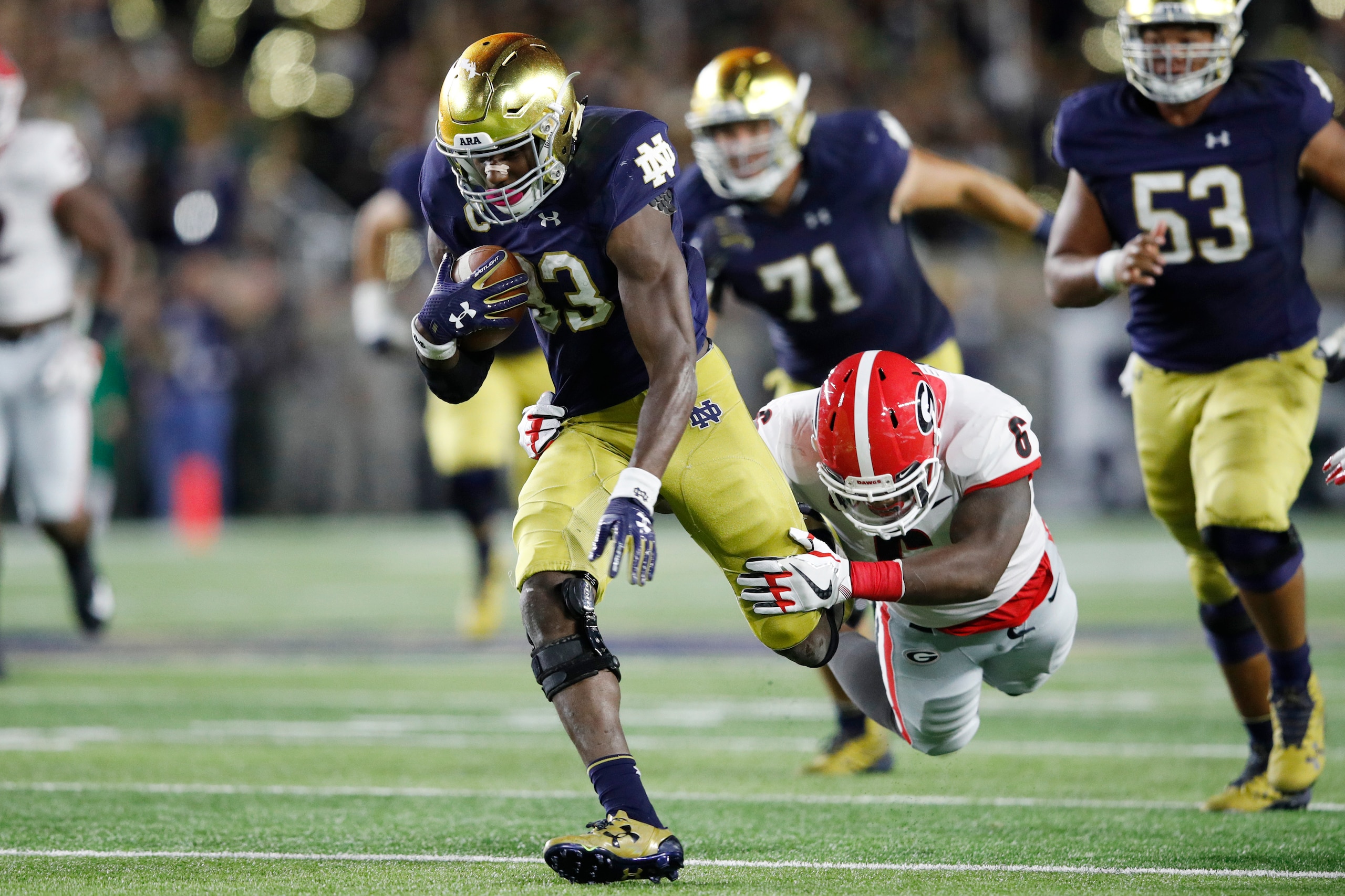 SOUTH BEND, IN - SEPTEMBER 09: Josh Adams #33 of the Notre Dame Fighting Irish runs through the tackle attempt from Natrez Patrick #6 of the Georgia Bulldogs in the second quarter of a game at Notre Dame Stadium on September 9, 2017 in South Bend, Indiana